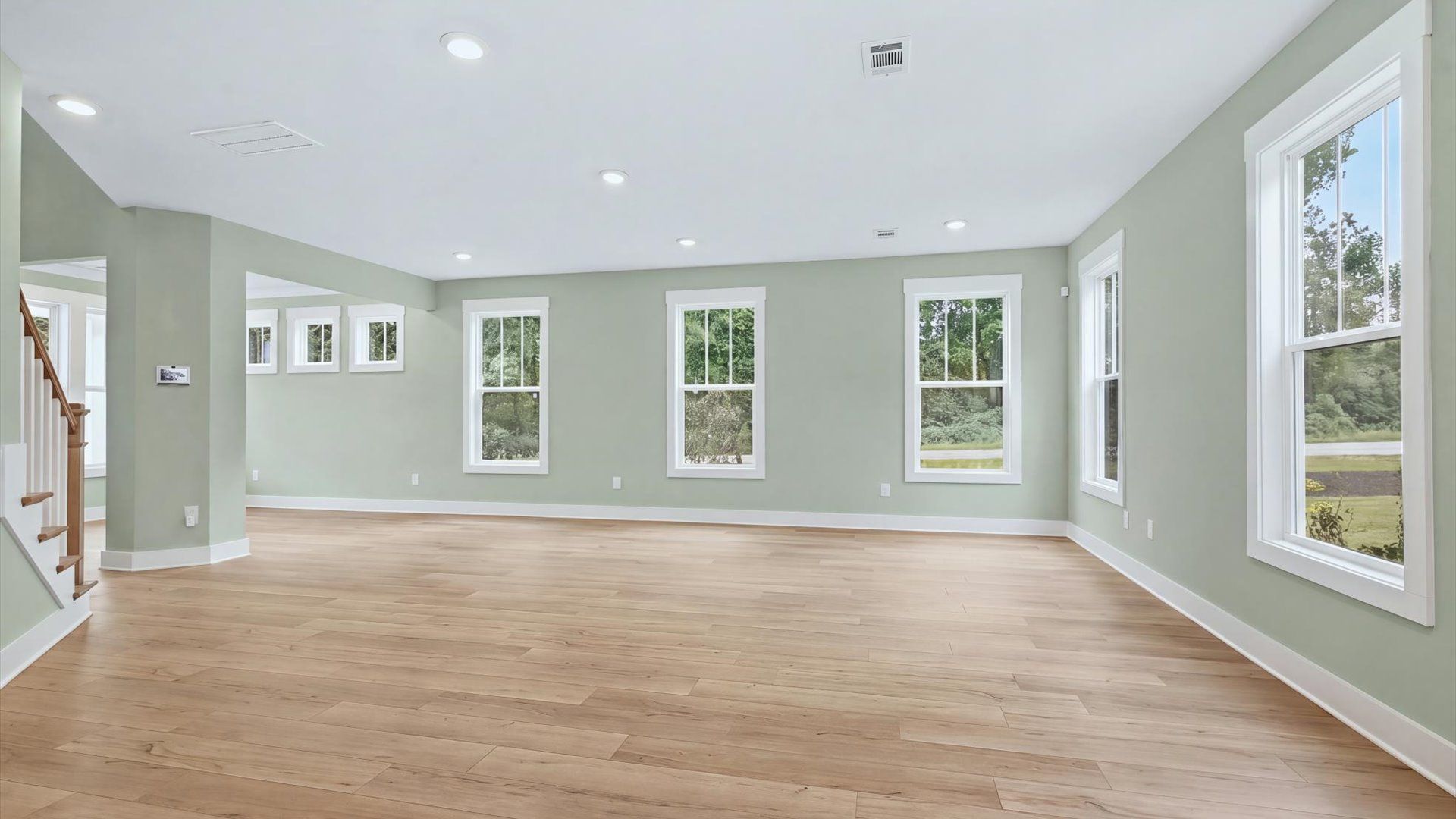 Elegant family room featuring hardwood flooring, large windows, and thoughtful architectural detail