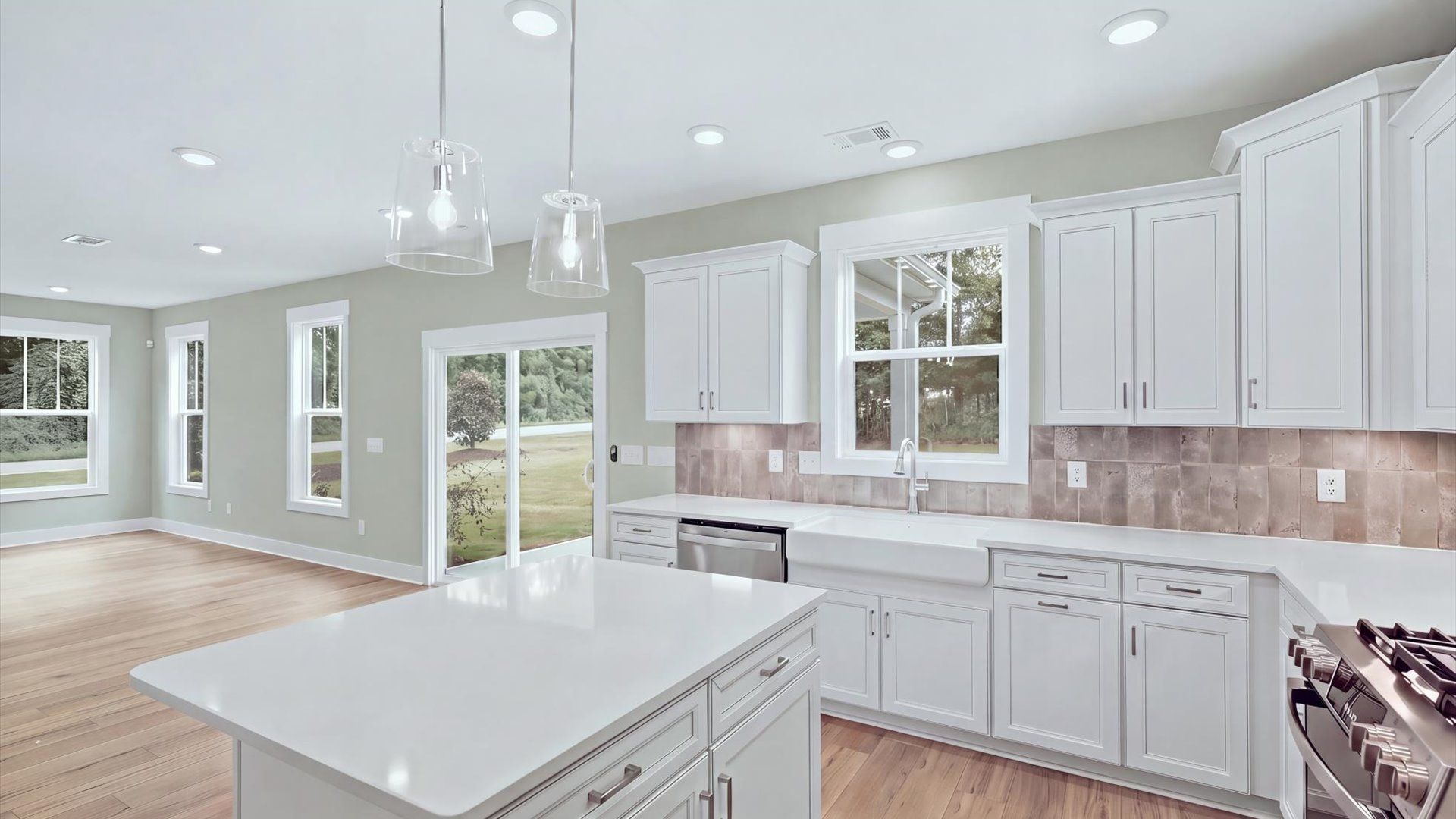 Accomplished kitchen design featuring pendant lighting above a statement island for both prep and gathering by DRB Homes