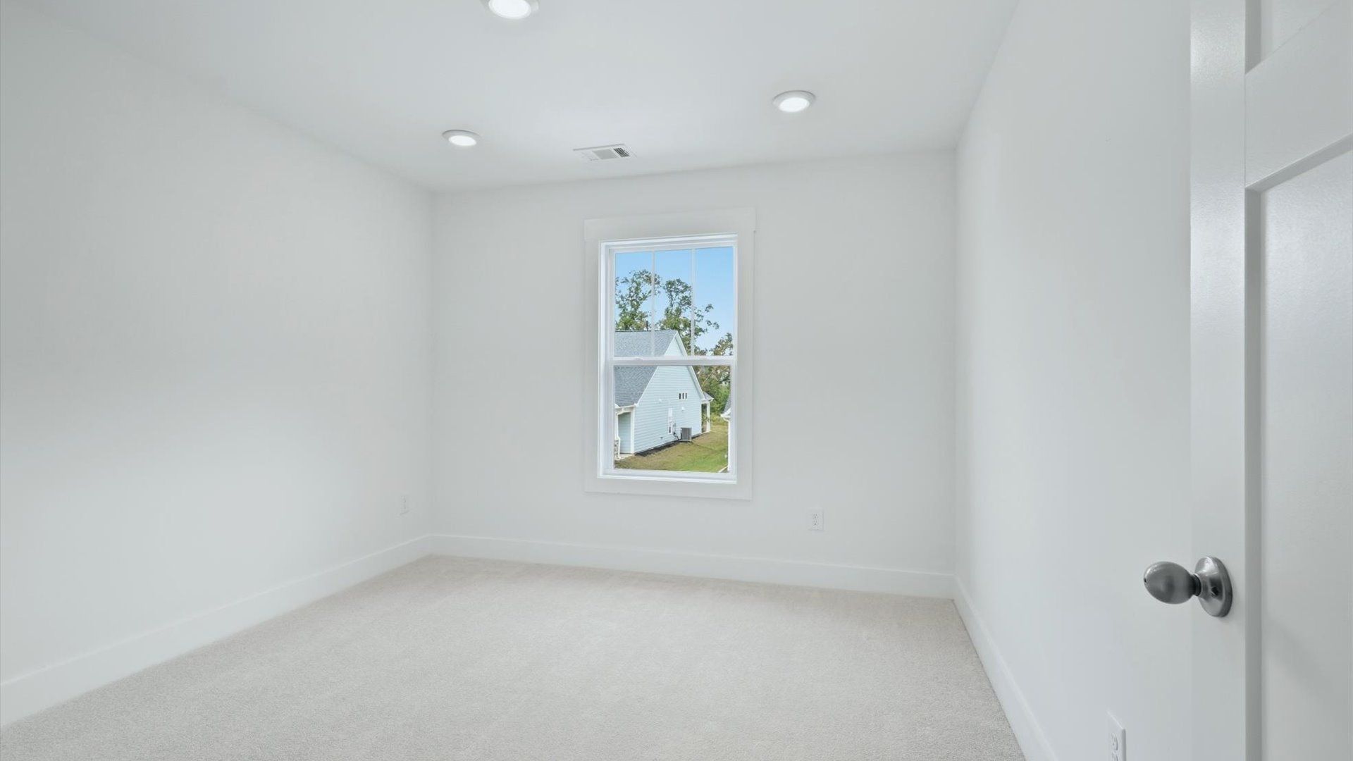 Notable bedroom offering soft carpet, a walk-in closet, and an expansive window overlooking the yard by DRB Homes