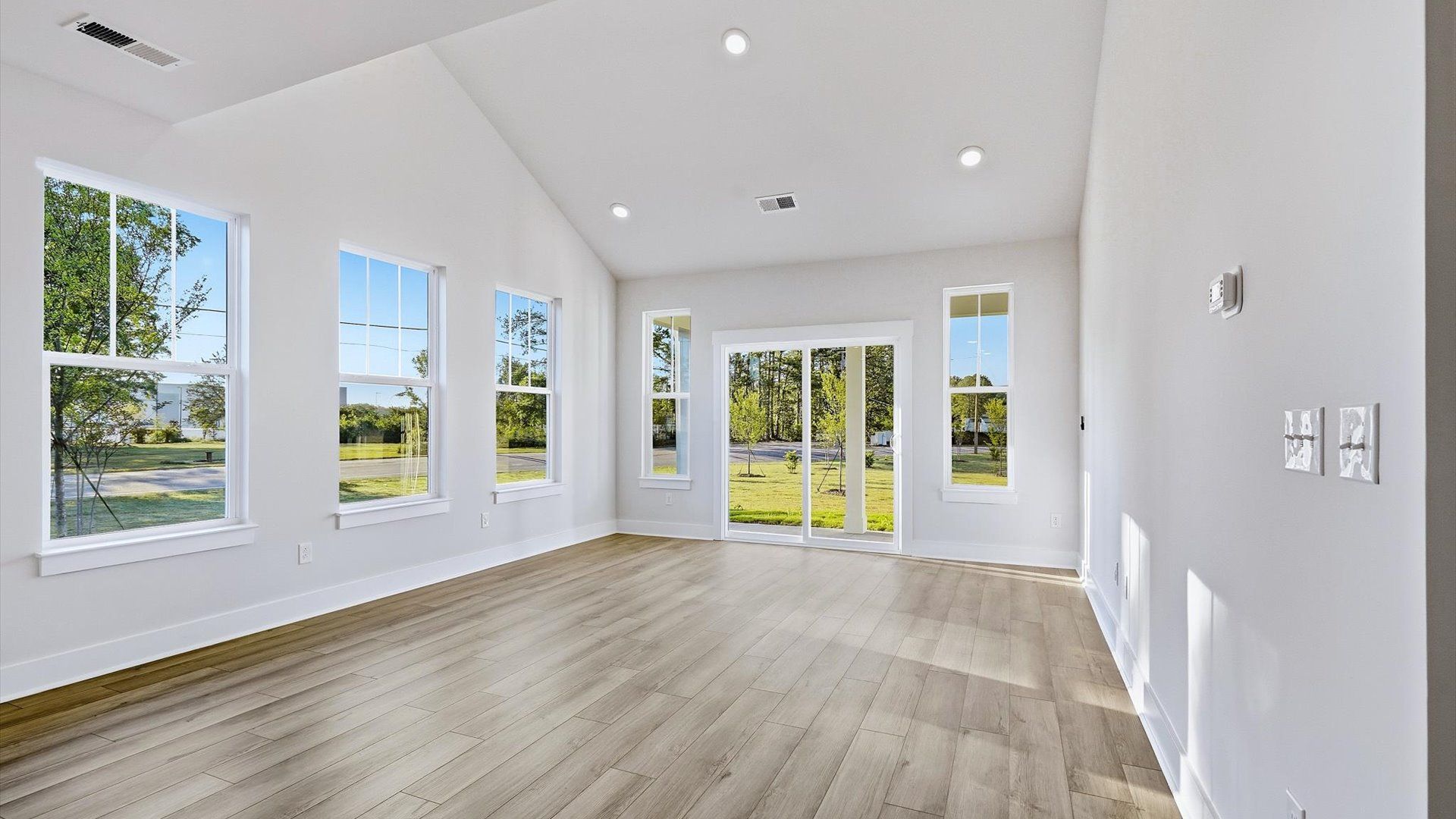 Spacious family room with rich hardwood flooring and elegant trim work in a reputable DRB Homes build
