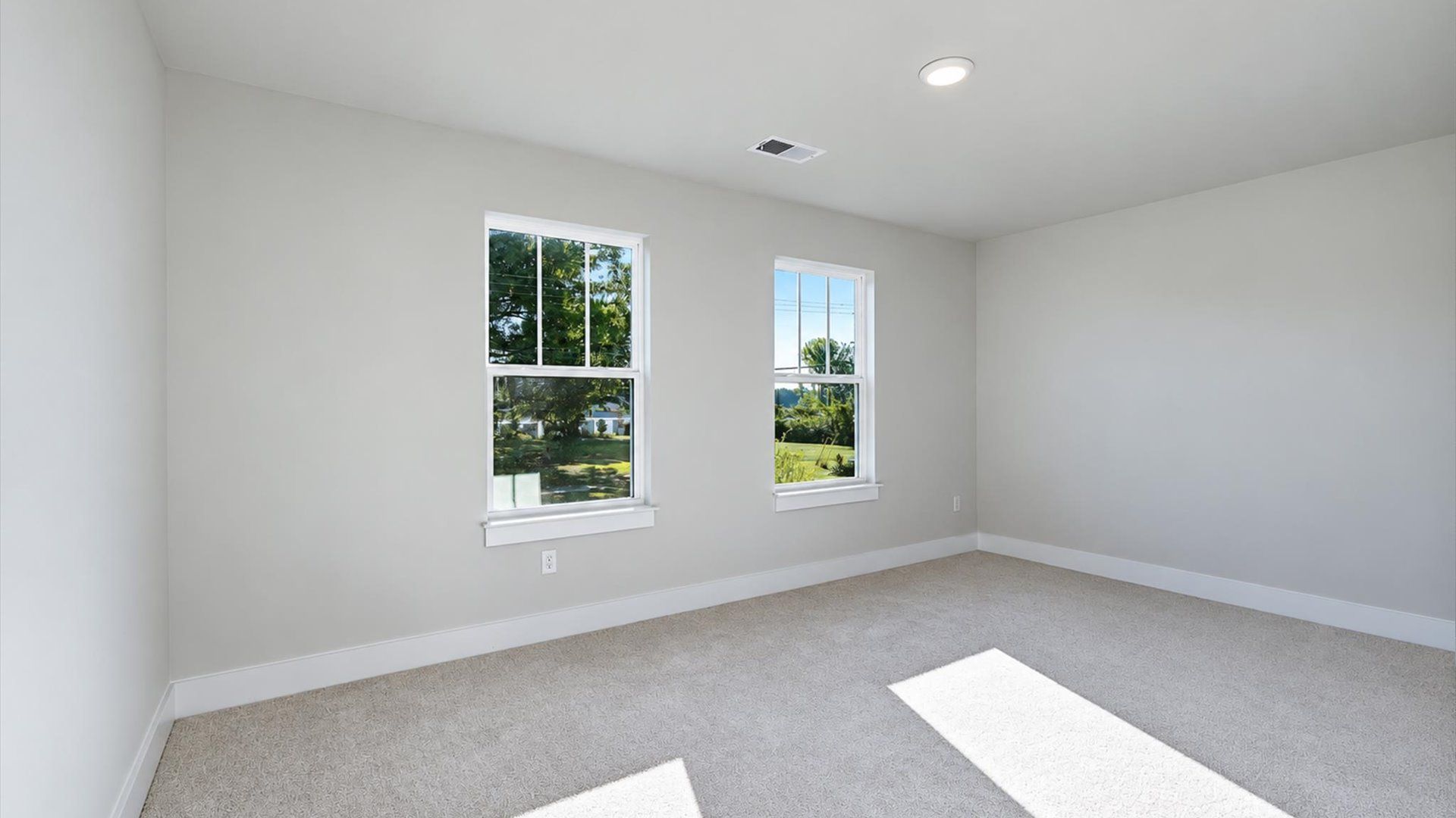 Tasteful bedroom with plush carpet, a walk-in closet, and large windows for abundant natural light by DRB Homes