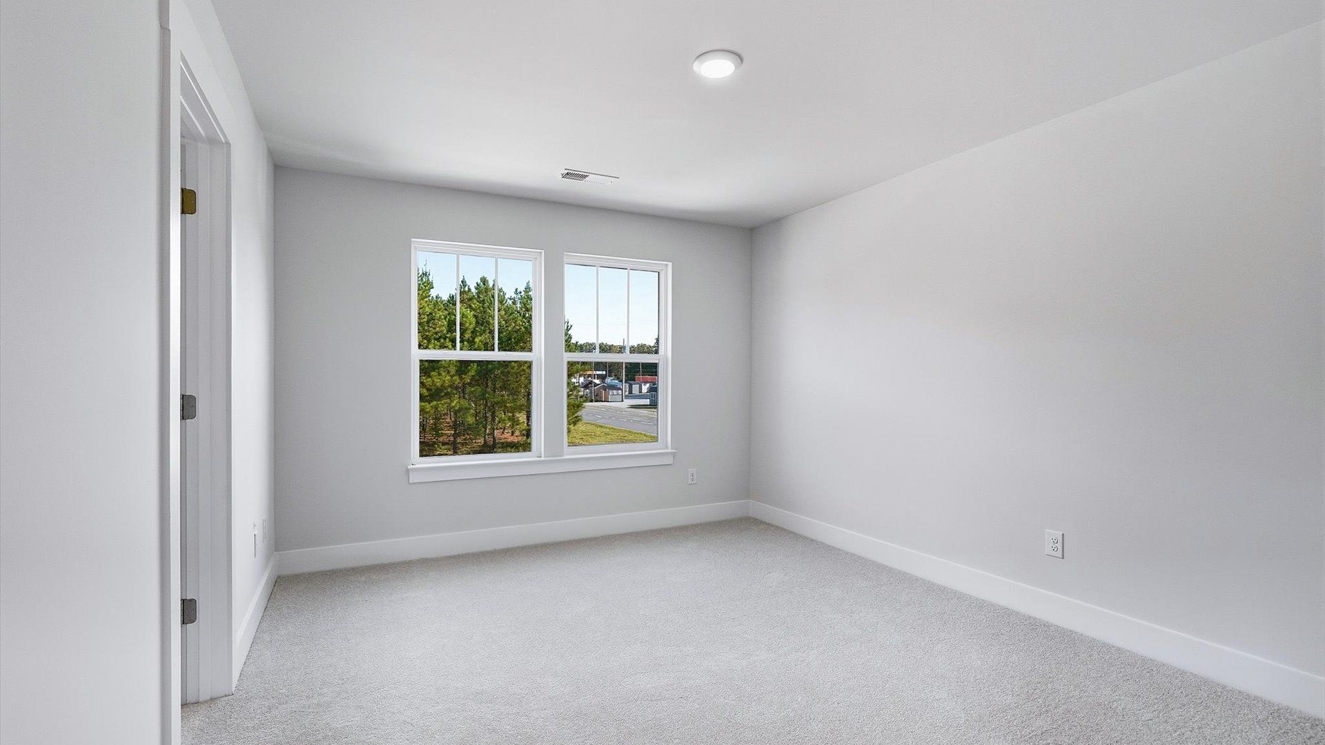 Notable bedroom offering soft carpet, a walk-in closet, and expansive windows overlooking the yard in Fountain Inn, SC