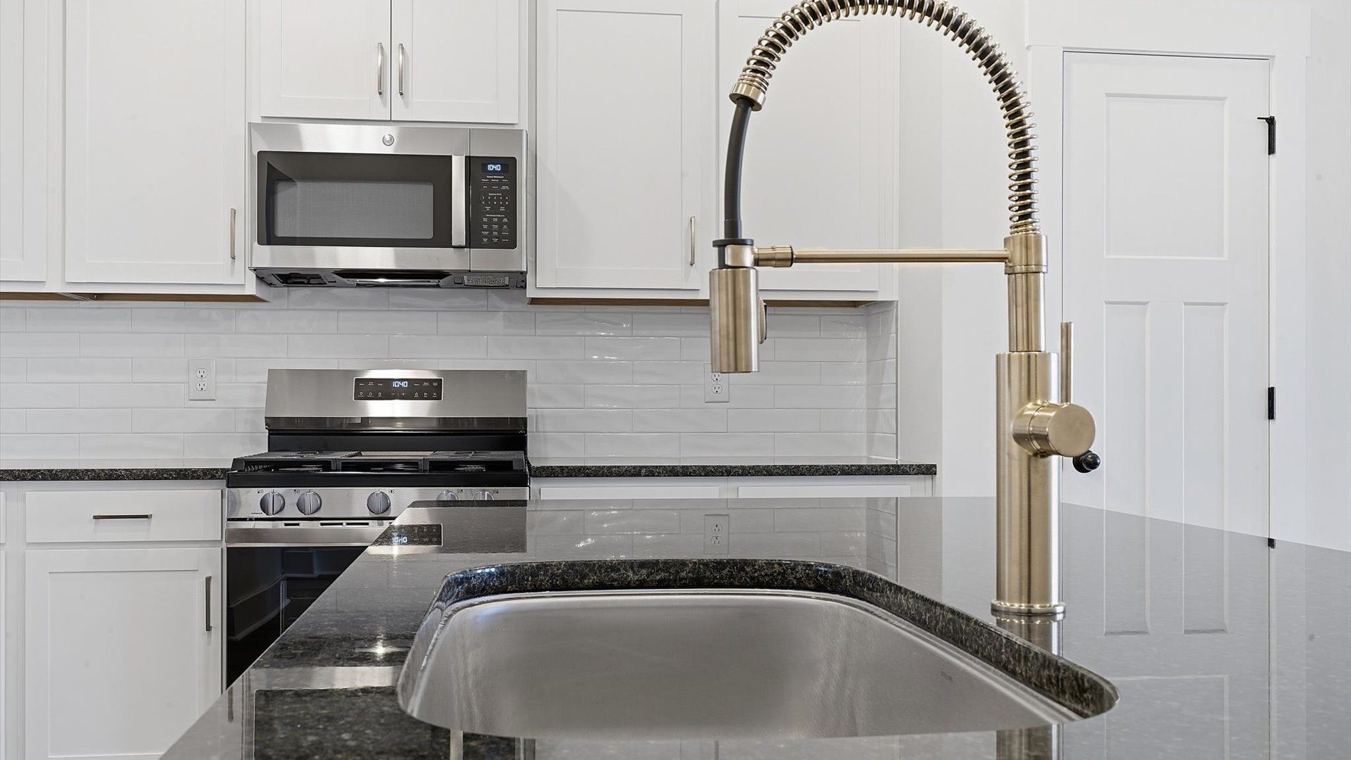 Well-designed kitchen with a center island and tasteful finishes that elevate everyday living by DRB Homes