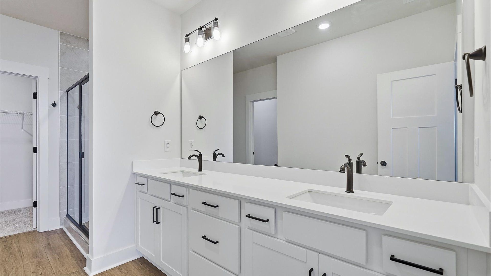 Highly functional and elegant en-suite with dual vanities, tiled walk-in shower, and refined finishes