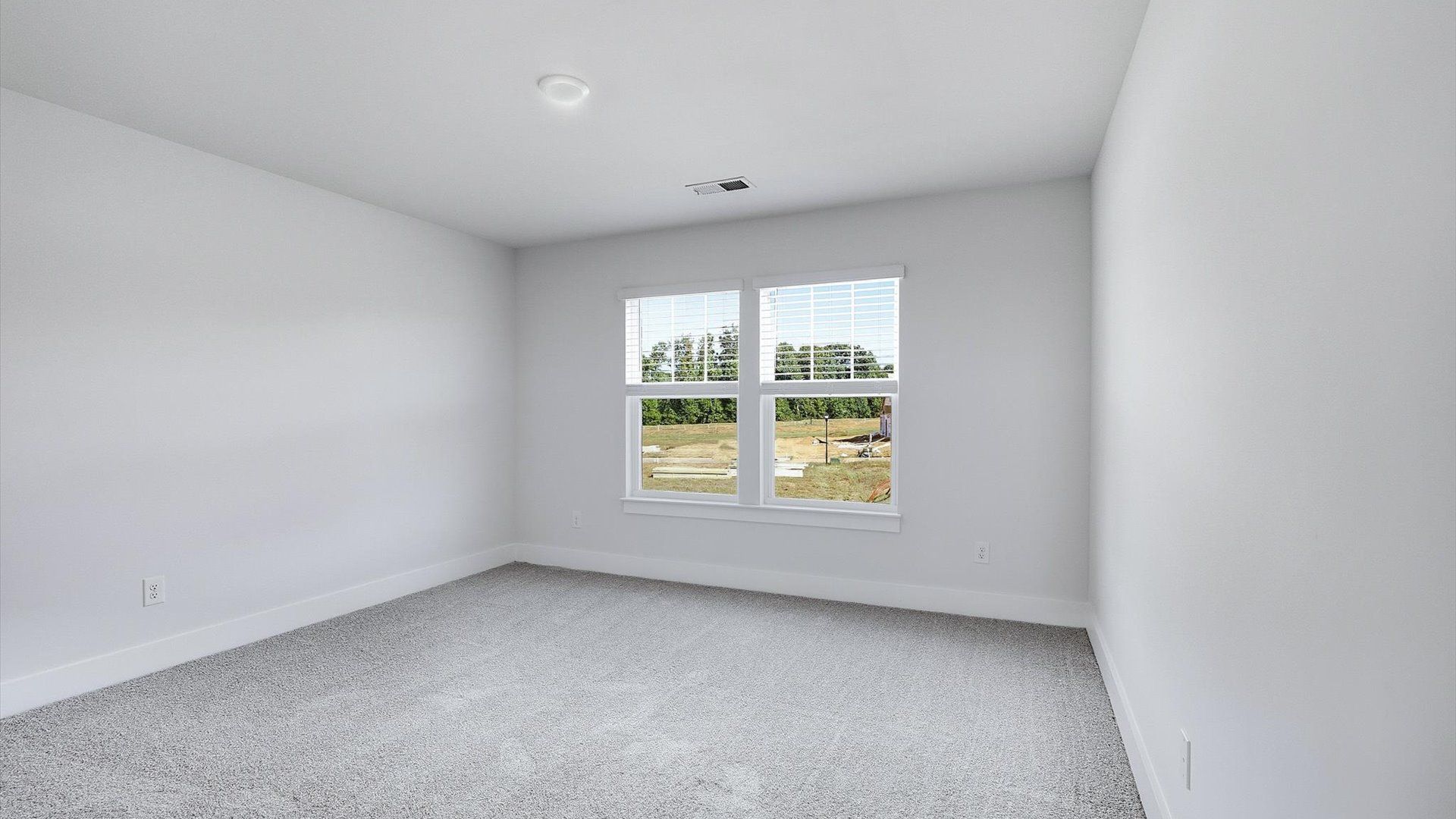 Highly functional bedroom with large windows, carpeted flooring, and tasteful finishes throughout by DRB Homes