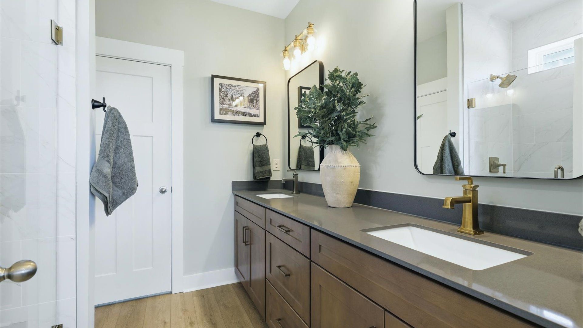 Highly functional and elegant en-suite with dual vanities, tiled walk-in shower, and refined finishes