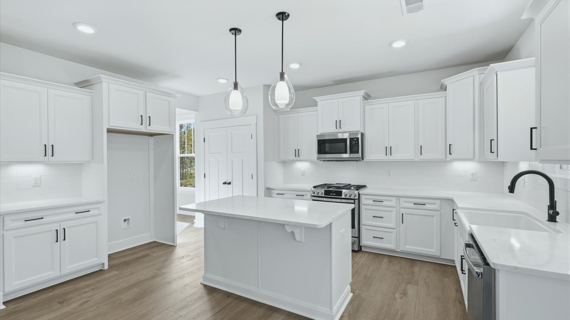 Elegant and compact island anchors this tasteful kitchen with high standards and timeless appeal by DRB Homes