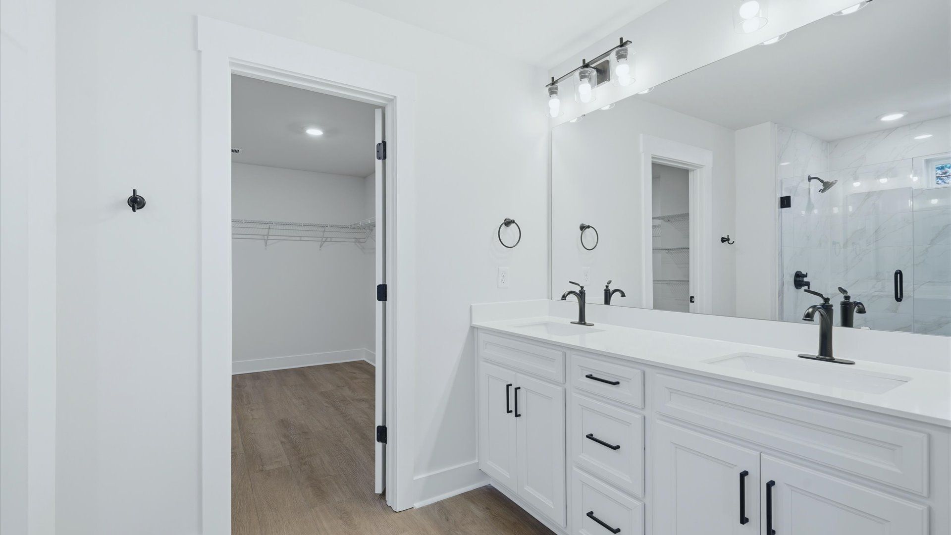 Notable primary bath featuring dual vanity, walk-in shower, and tasteful design touches throughout by DRB Homes