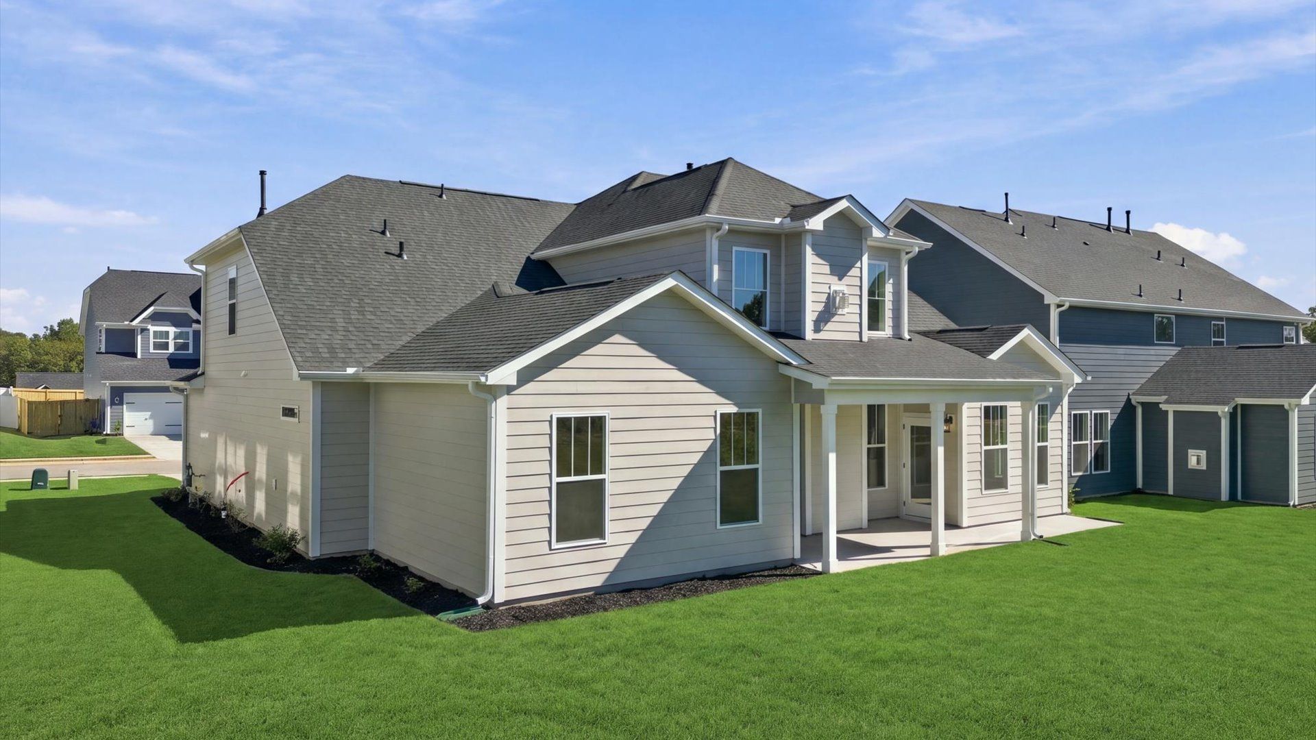 Refined rear exterior with a stylish covered porch for dining, relaxing, or entertaining by DRB Homes