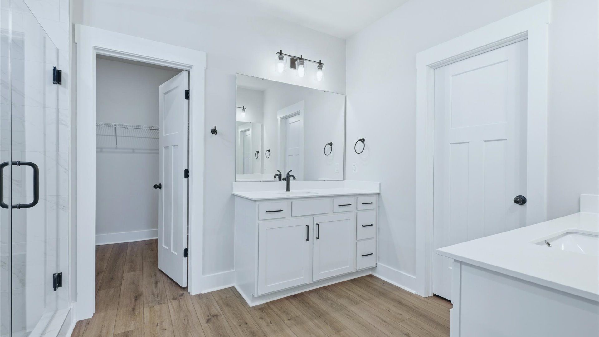 Tasteful primary bath with modern finishes, a walk-in shower, and thoughtful double vanity layout by DRB Homes