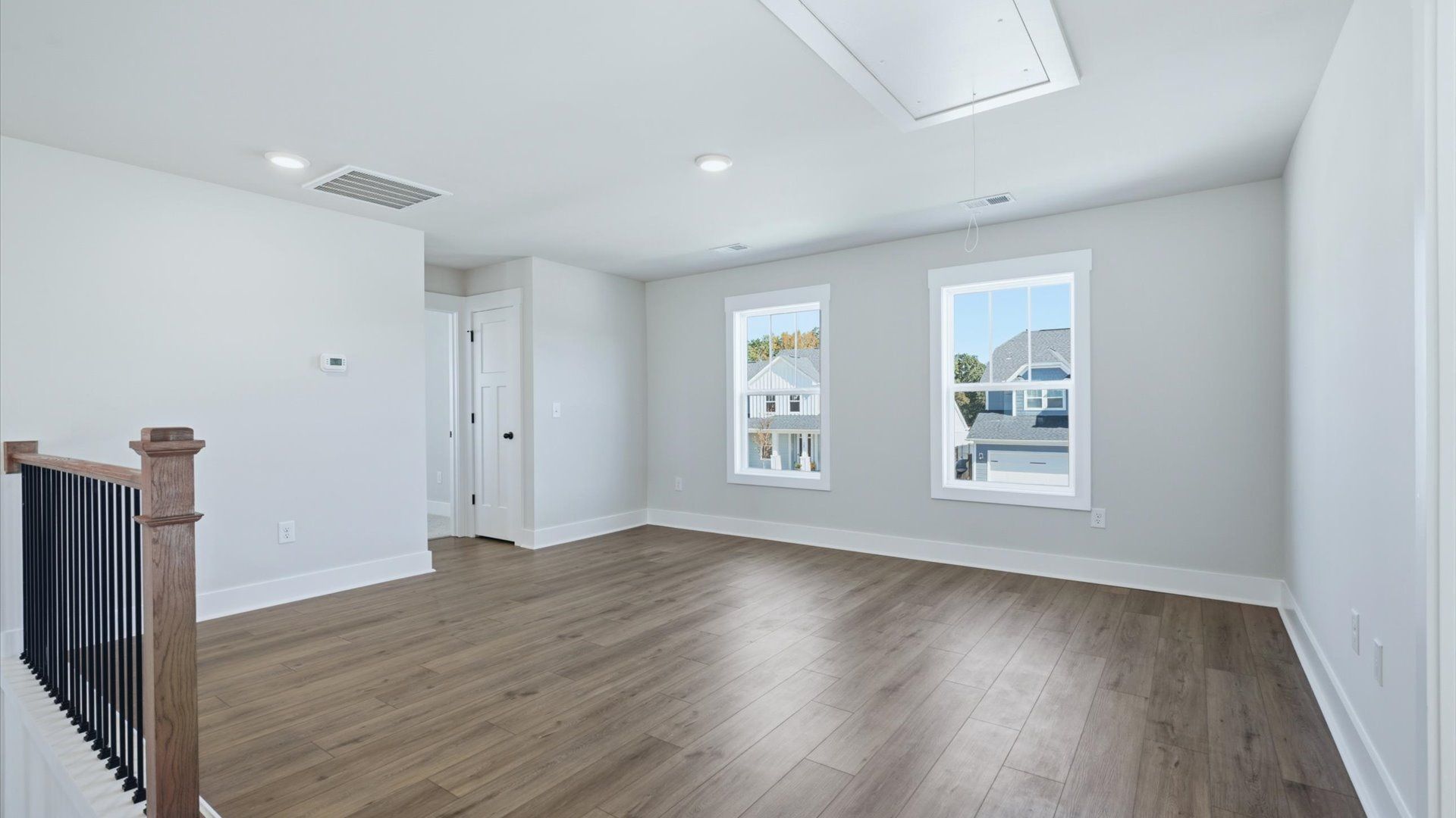 Functional loft with tasteful hardwood floors and exceptional natural light in a modern home by DRB Homes
