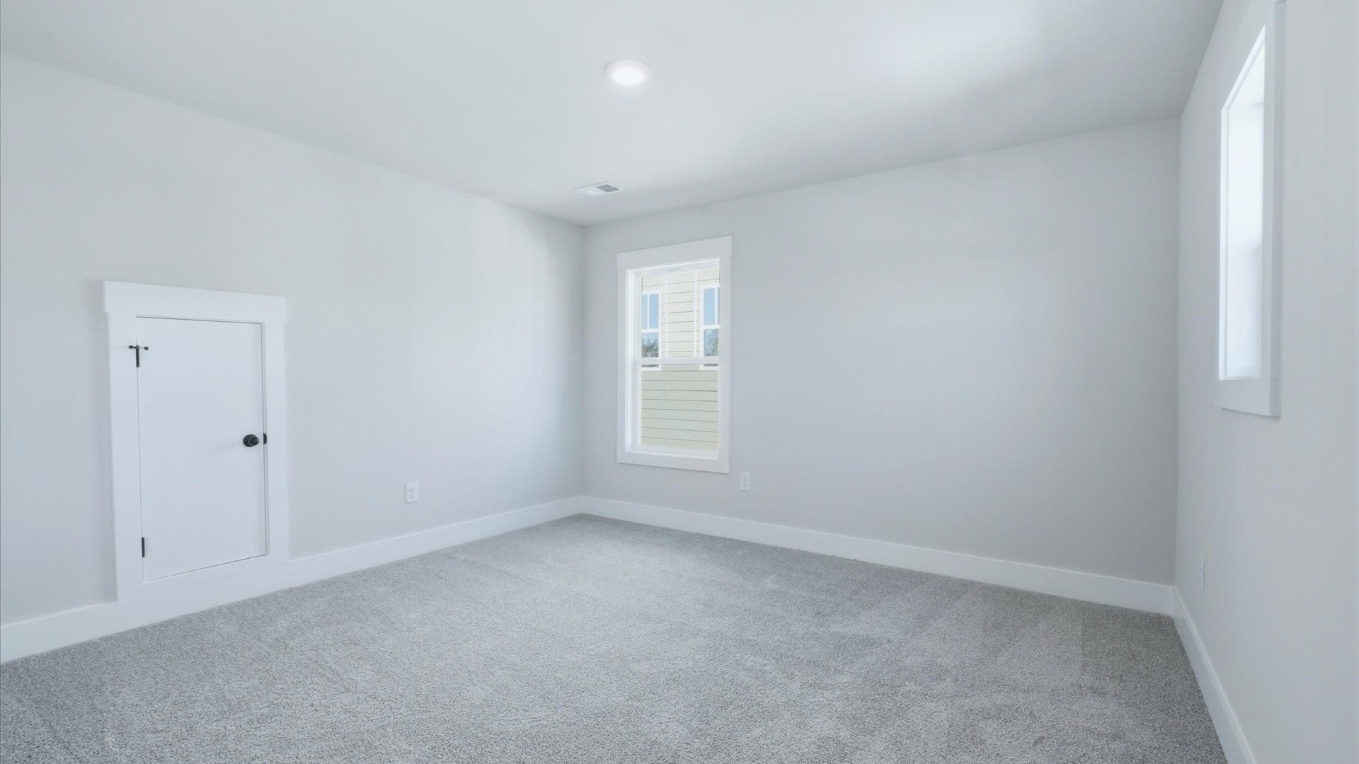 Accomplished design in this restful bedroom featuring plush carpet and oversized window views at Kayfield at Midway