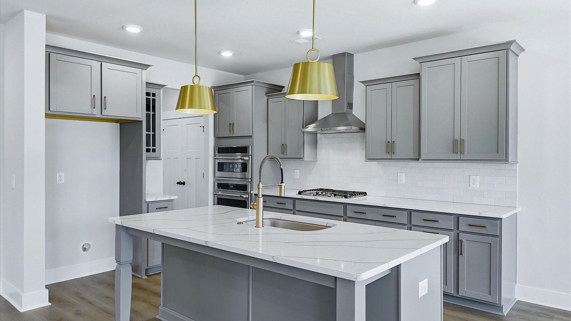Elegant kitchen with large island and pendant lighting in this first-class DRB Homes design