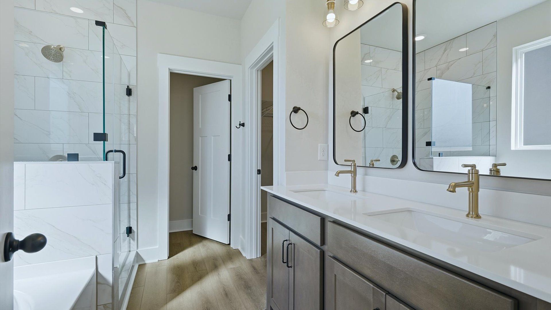 Tasteful primary bath with modern finishes, a walk-in shower, and thoughtful double vanity layout by DRB Homes