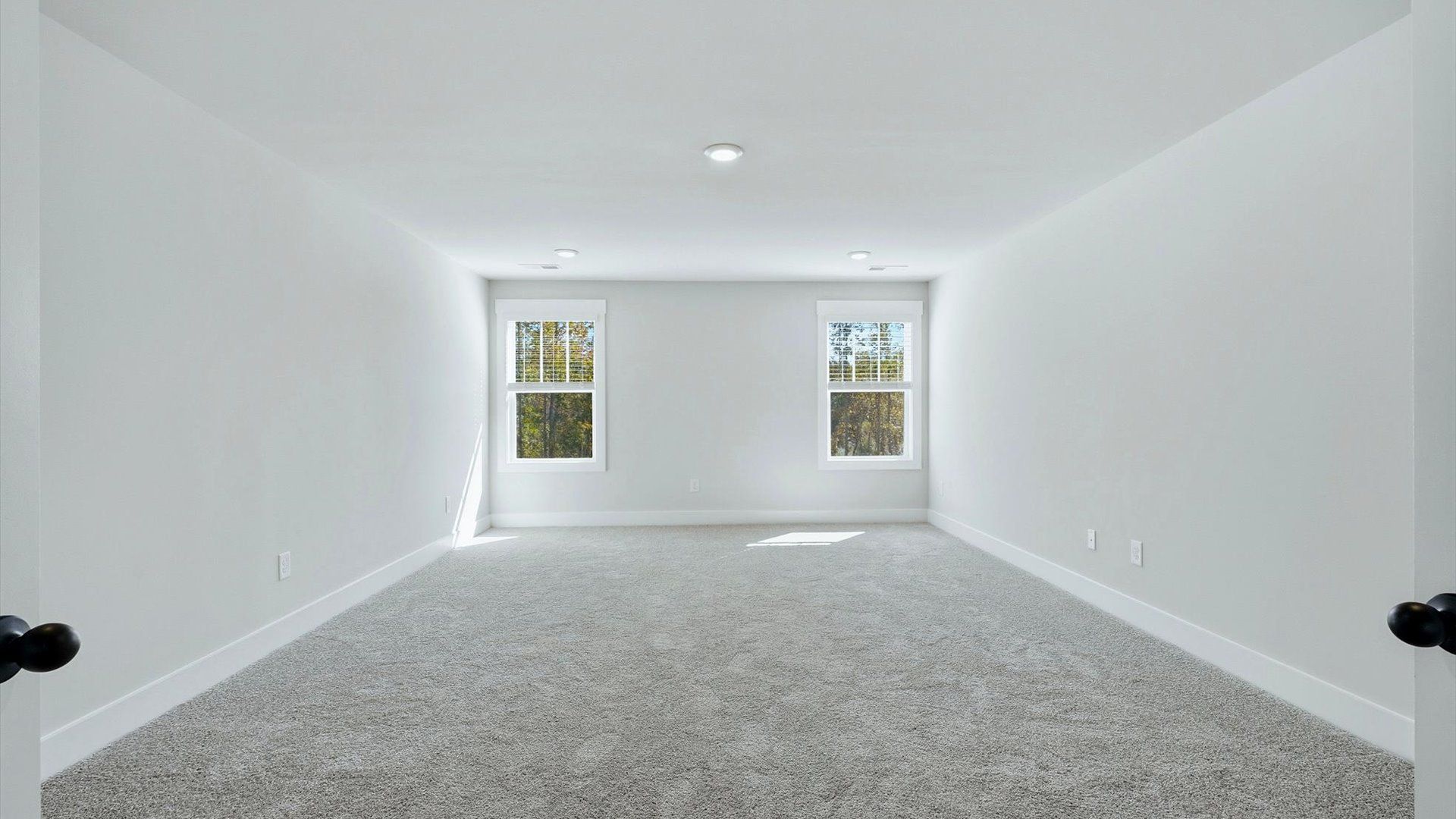 Refined bonus room with comfortable carpeted flooring and tasteful design throughout by DRB Homes