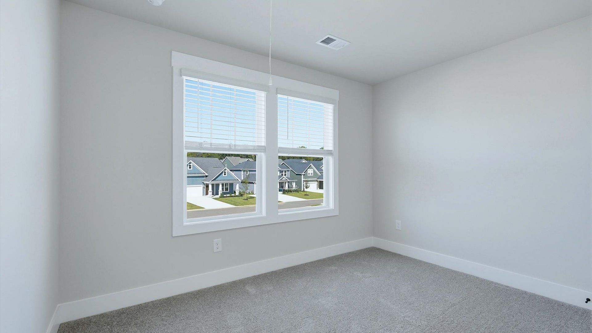 Bright and serene bedroom with comfortable carpeted flooring and large windows for vibrant light by DRB Homes