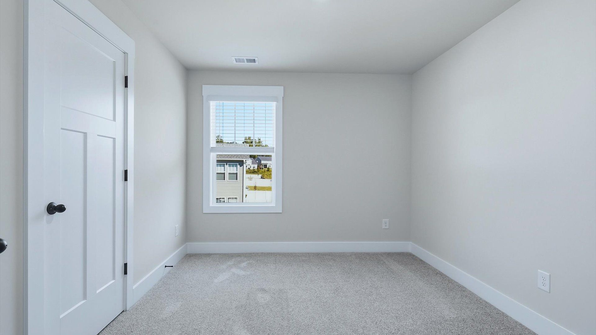 Elegant bedroom retreat featuring soft carpet and oversized windows that create a bright, welcoming space