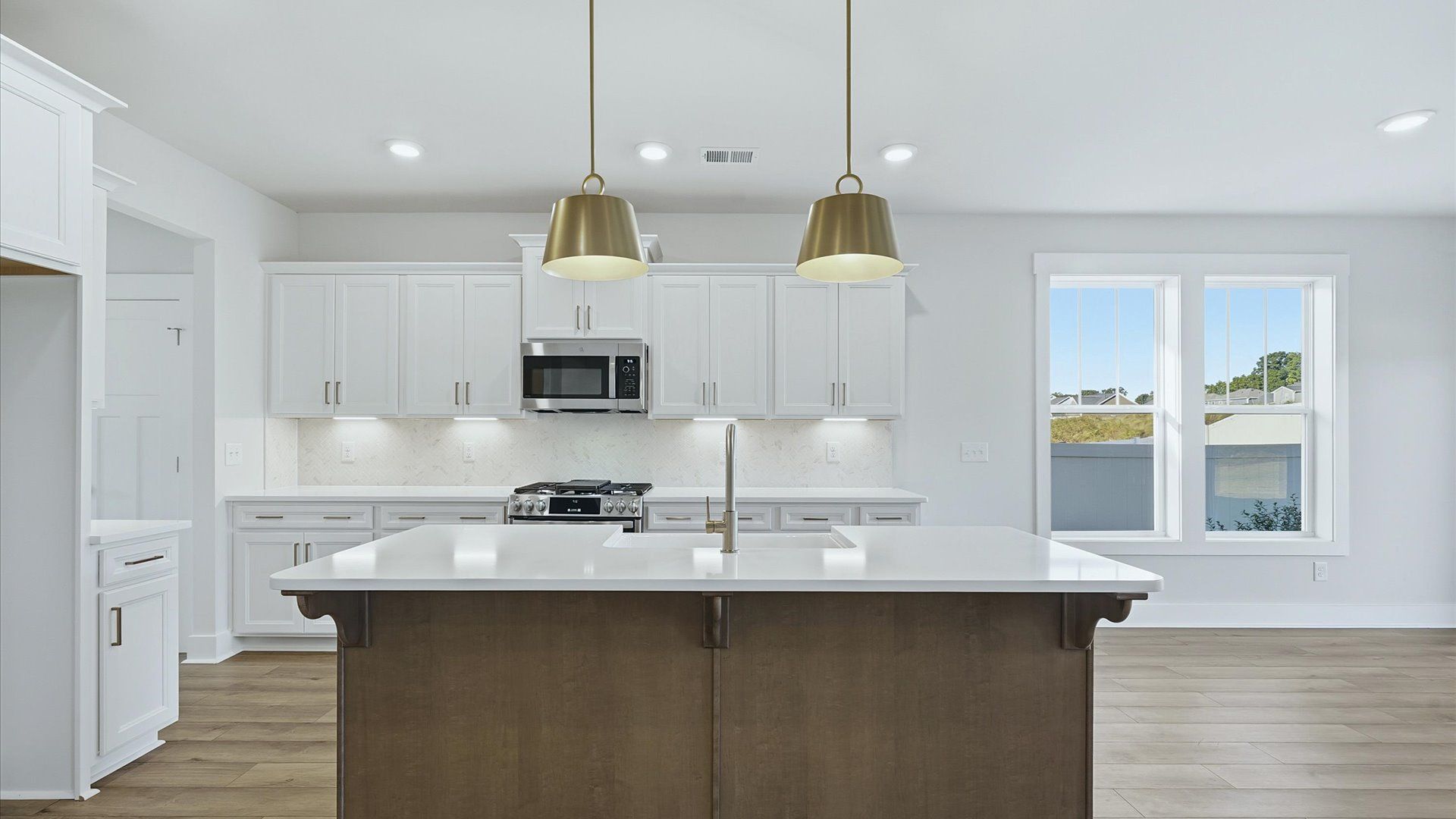 Elegant kitchen with large island and pendant lighting in this first-class DRB Homes design