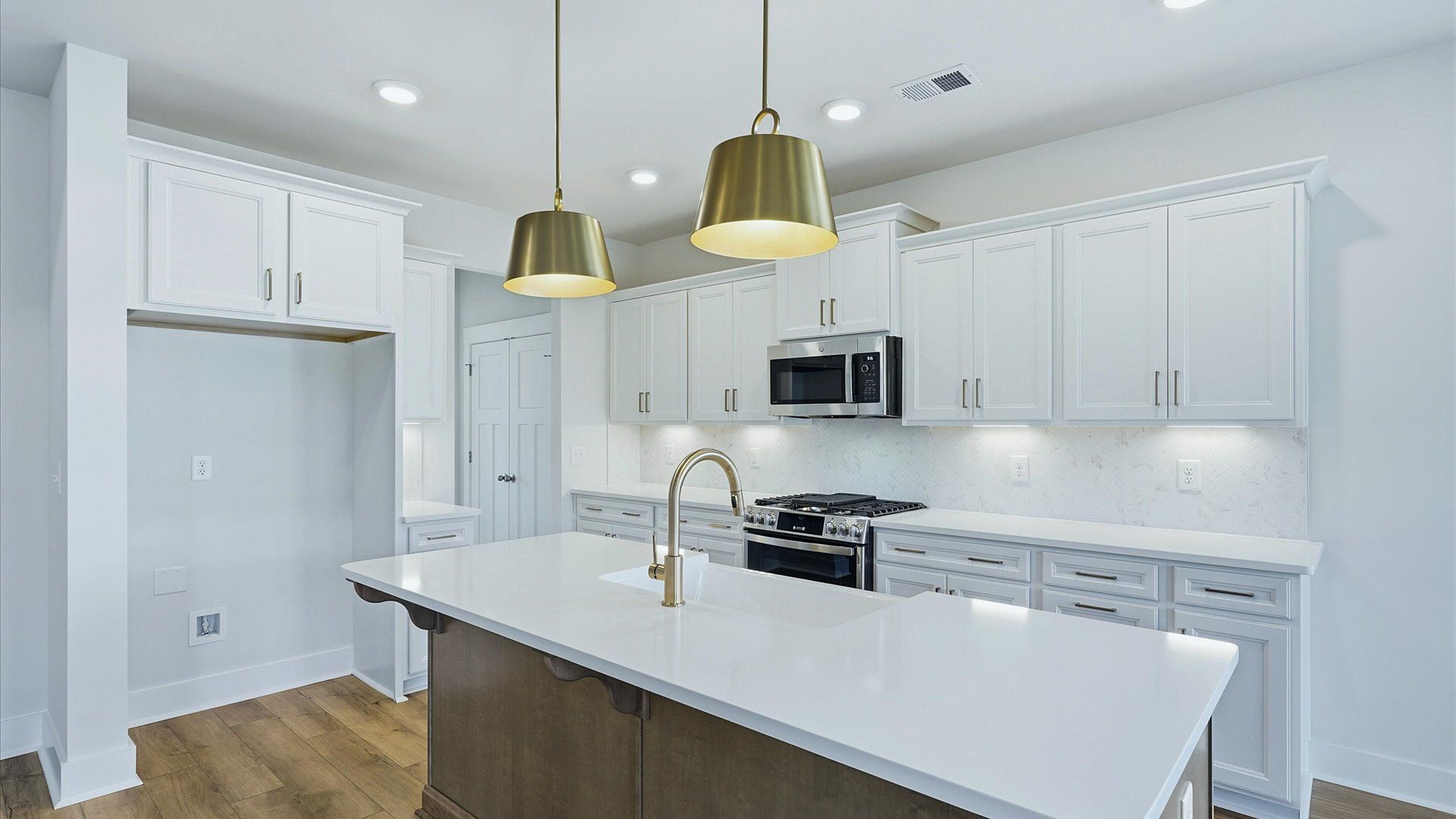 Exclusive DRB Homes kitchen with a 9-foot island, elevated finishes, and pendant lighting in a prime location