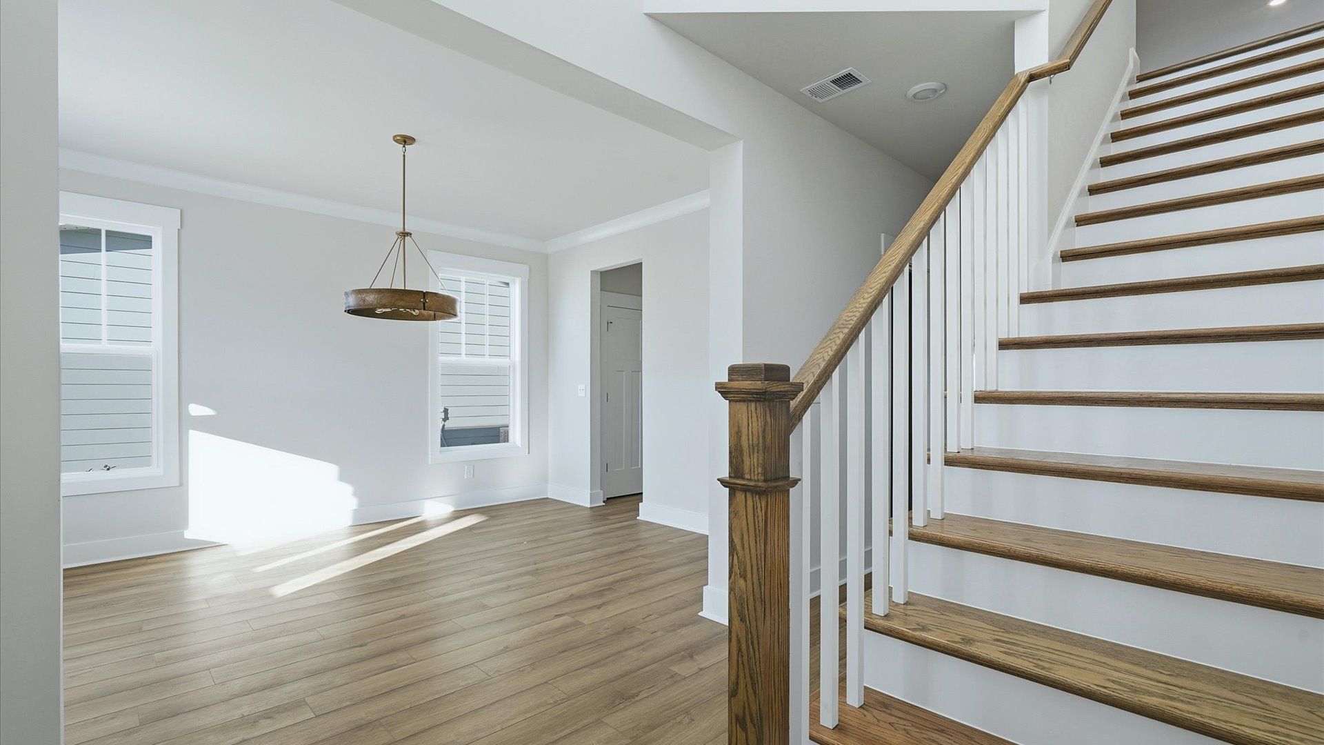 Accomplished hardwood flooring foyer sets the tone for tasteful design throughout the home by DRB Homes