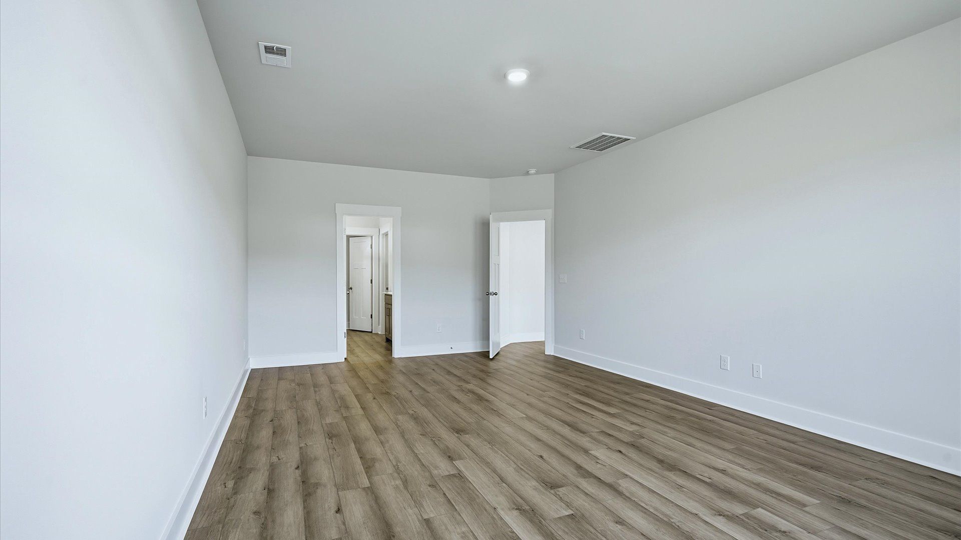 Serene and stylish primary bedroom featuring hardwood flooring and a thoughtful, modern layout at Mulberry Estates