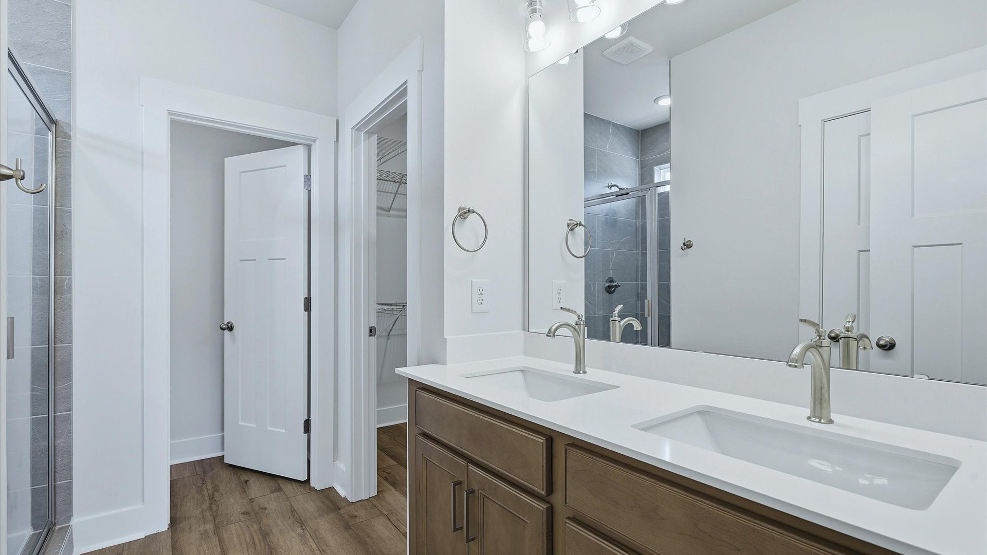 Memorable mornings begin in this elegant primary bathroom with walk-in shower and double vanity by DRB Homes