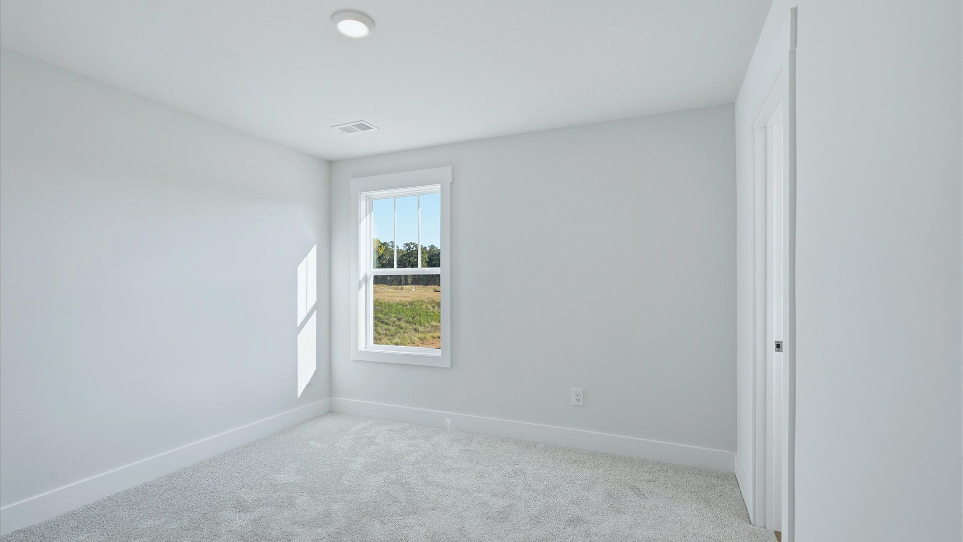 Highly functional bedroom with large windows, carpeted flooring, and tasteful finishes throughout at Mulberry Estates