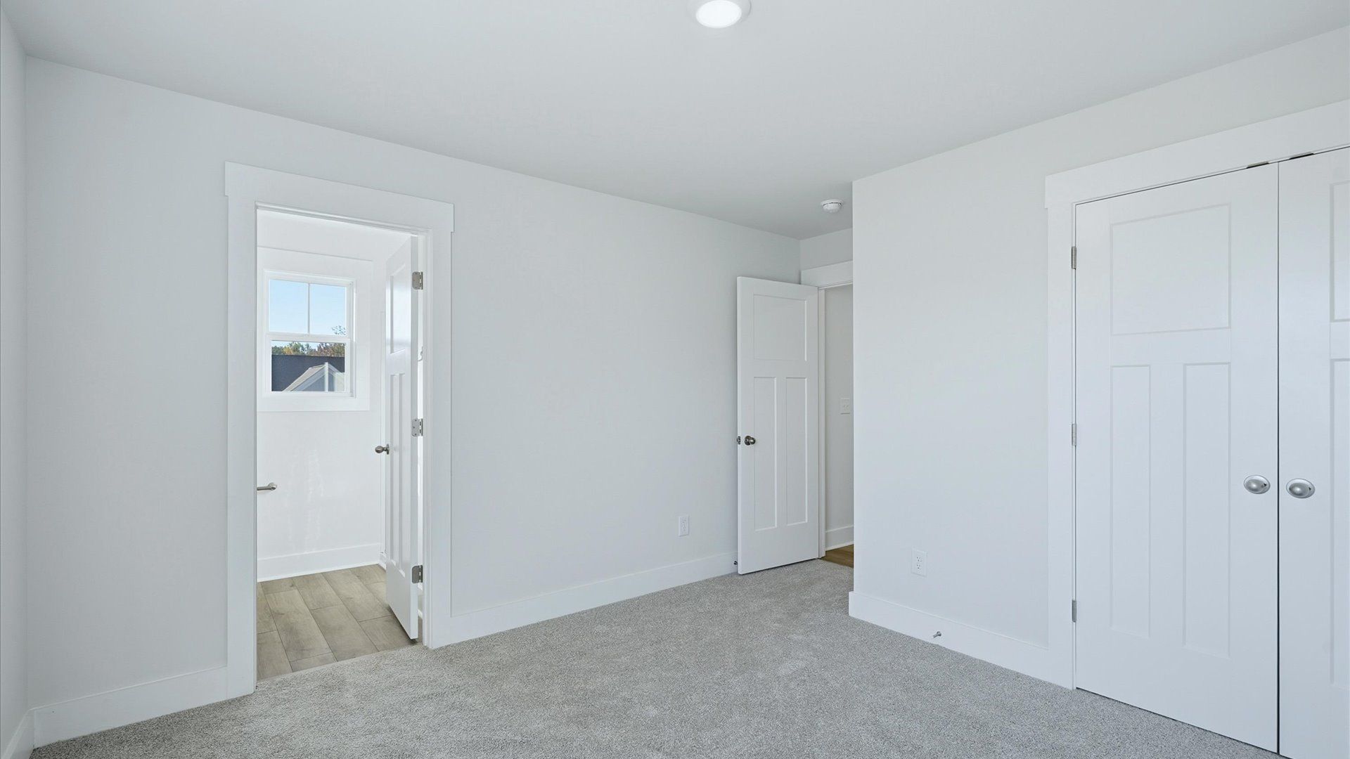 Elegant bedroom retreat featuring soft carpeting and a thoughtfully designed walk-in closet by DRB Homes