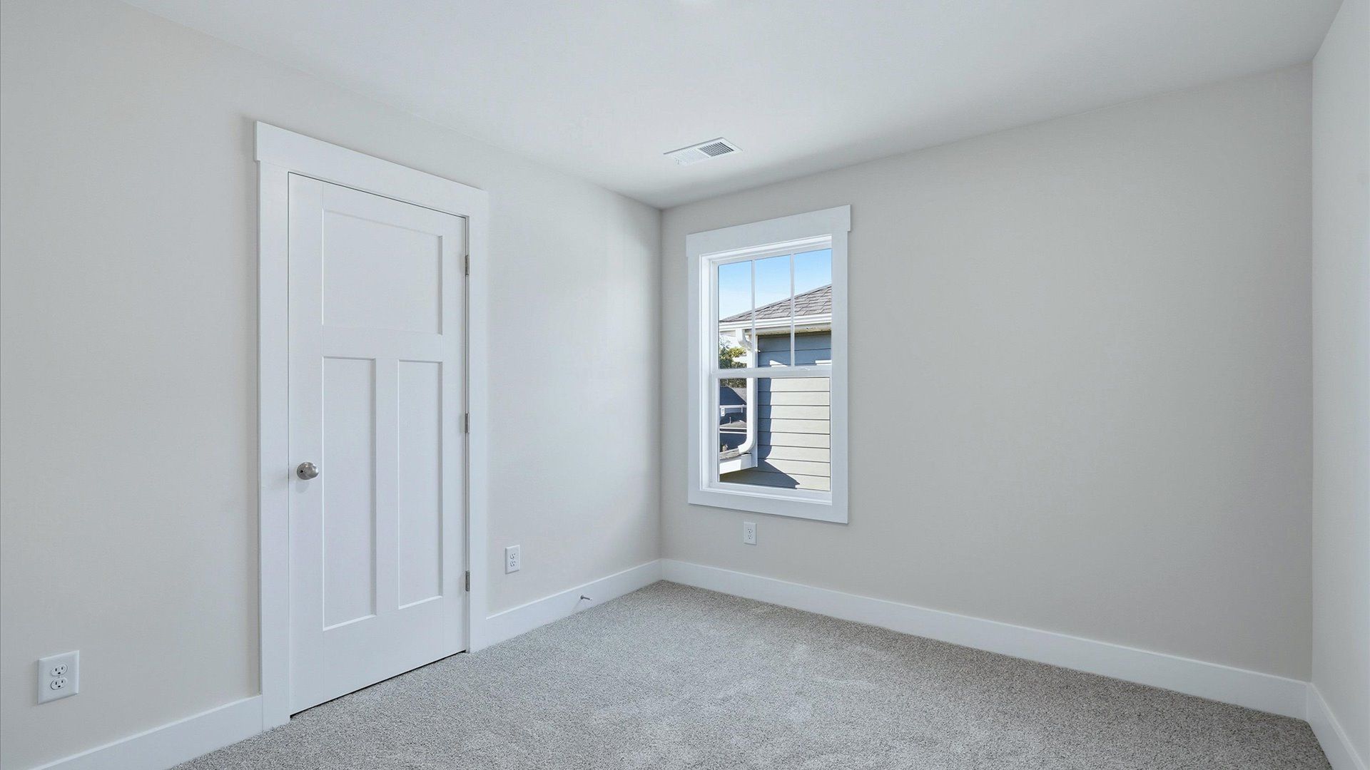 Inviting bedroom with tasteful finishes and a large window that creates a fresh, open ambiance