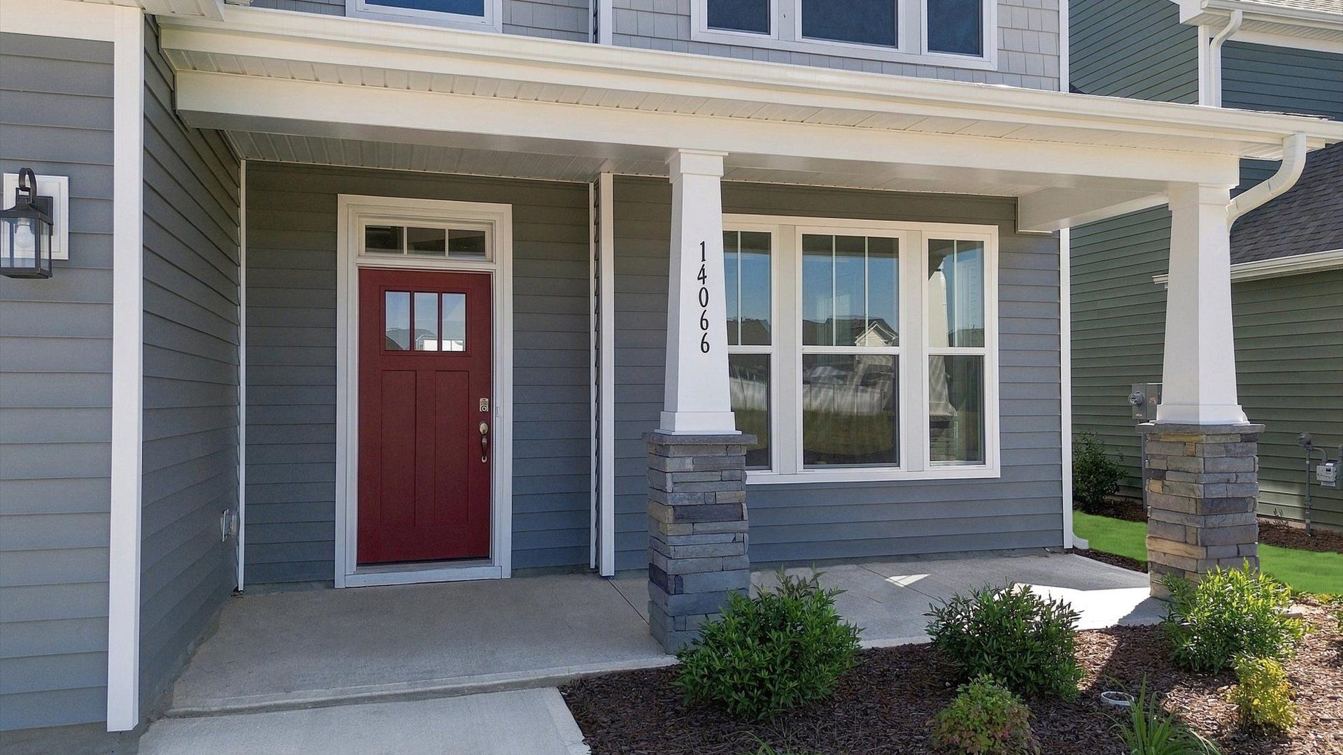 Elevated curb appeal with timeless stone accents and a welcoming covered entry near Lake Bowen
