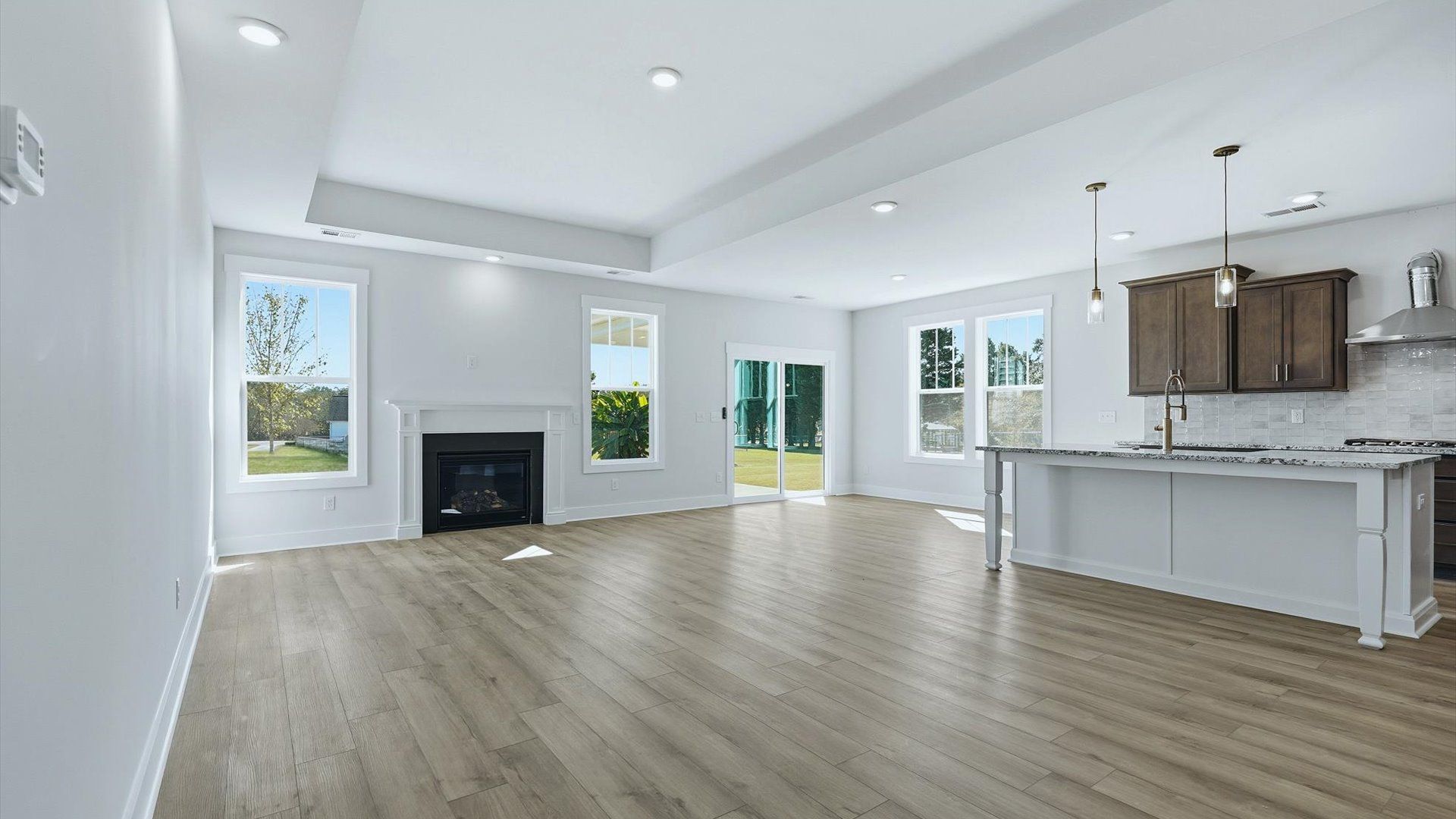 Elegant family room featuring hardwood flooring, large windows, and thoughtful architectural detail by DRB Homes