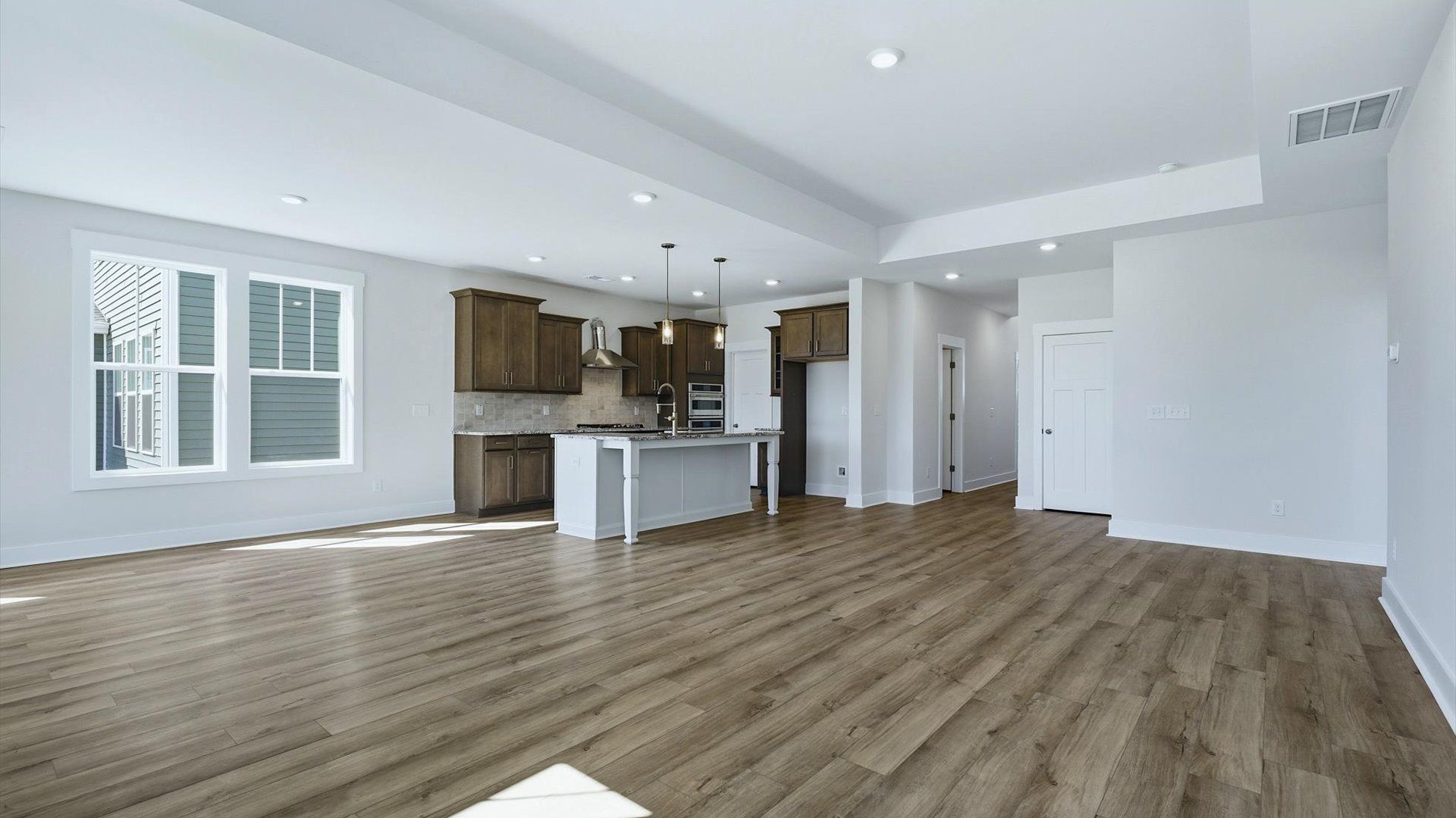 Hardwood flooring and high standards define this vibrant family room ideal for everyday living by DRB Homes