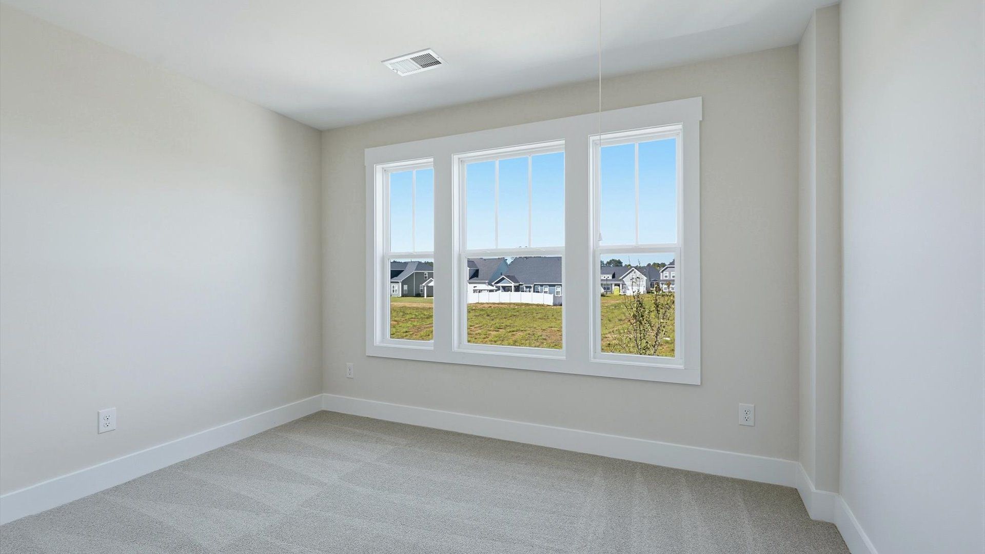 Highly functional bedroom with large windows, carpeted flooring, and tasteful finishes throughout at Walnut Ridge