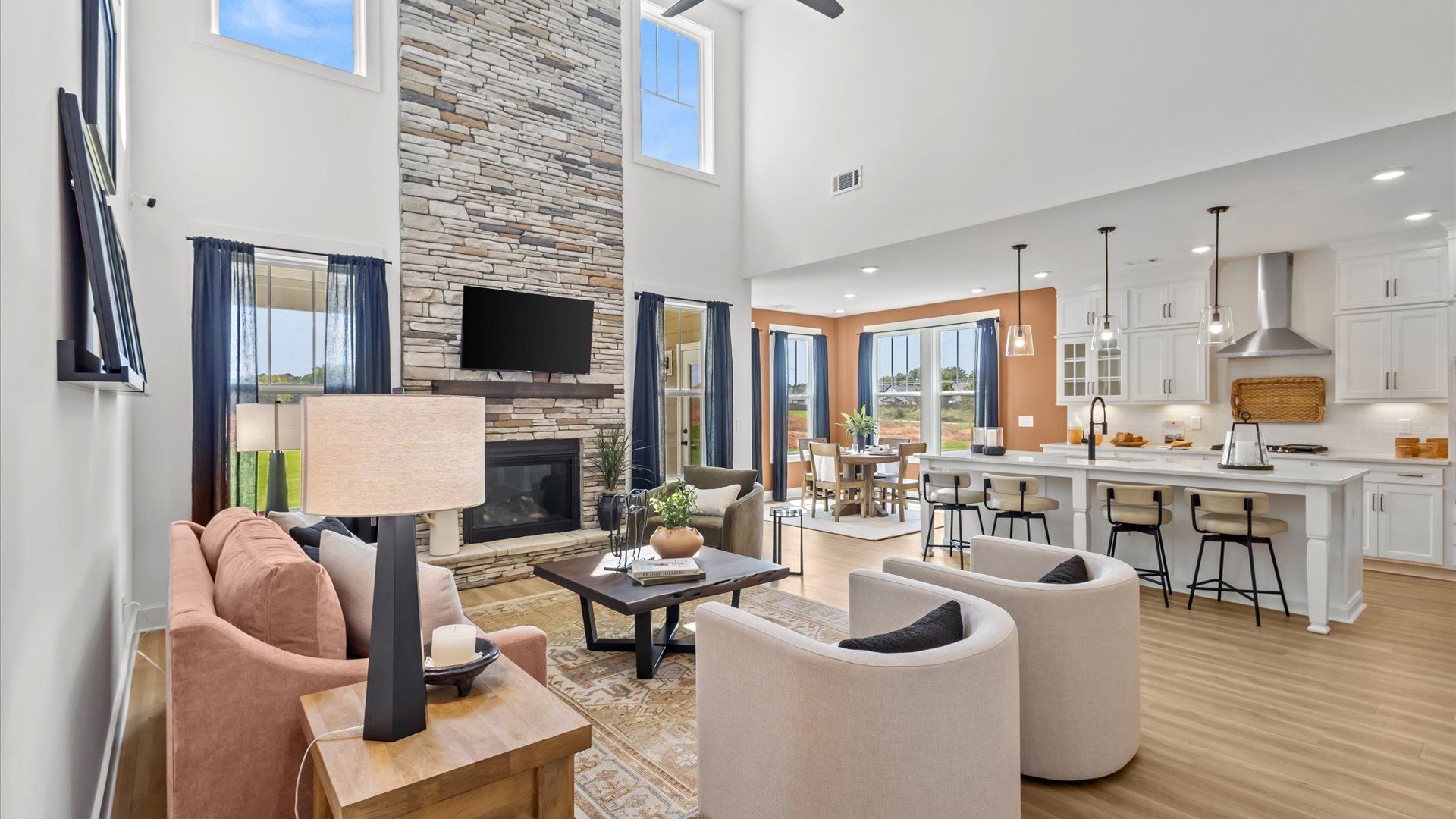 Tasteful family room with two-story volume, refined finishes, and exceptional natural light by DRB Homes