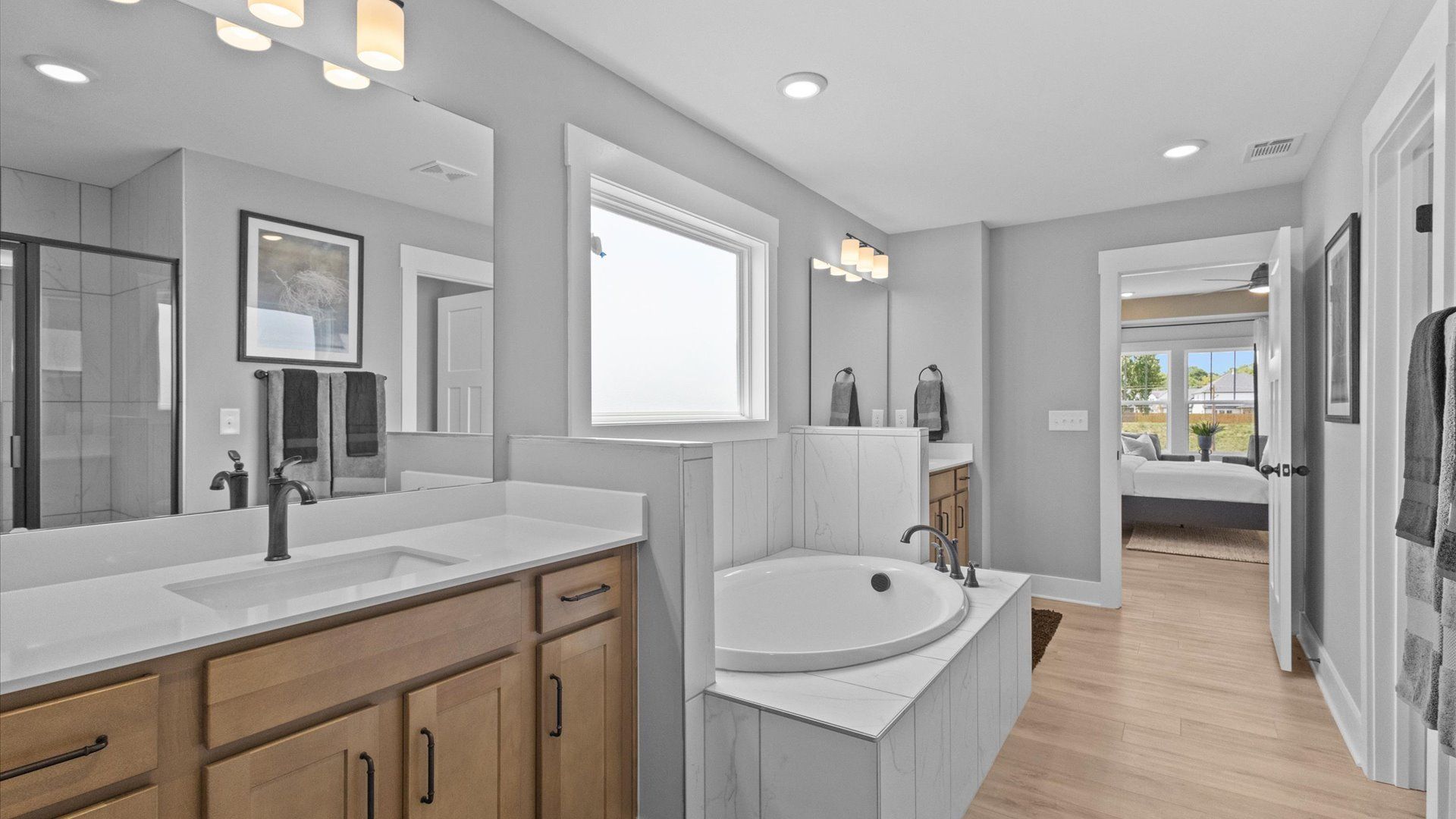 Highly functional and elegant en-suite with dual vanities, tiled walk-in shower, and refined finishes
