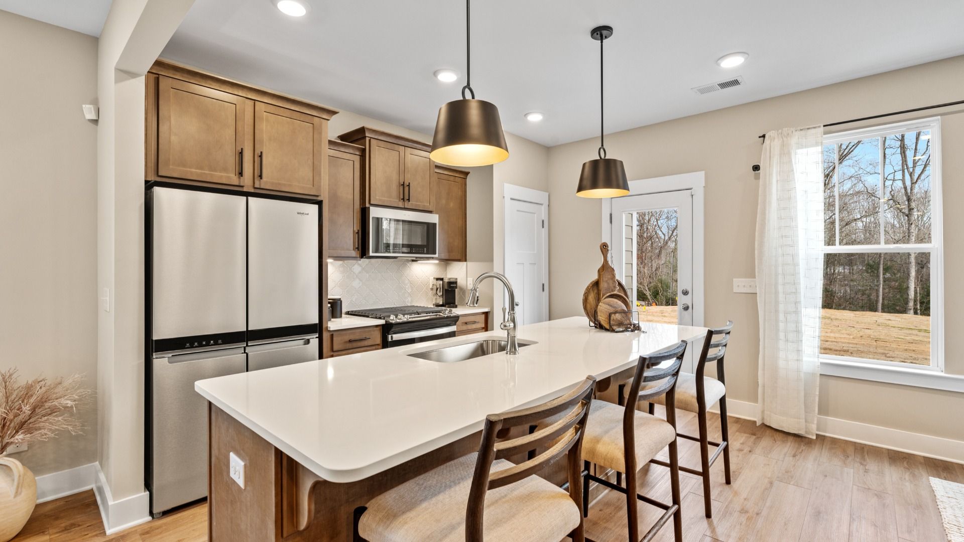 Kitchen with Whirlpool Appliances, natural light brown cabinets and large island with quartz countertops in Lyman, SC