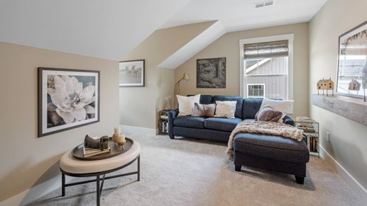 Summit floorplan bonus room with cozy carpet, a large window, and beige walls at Aspen Ridge
