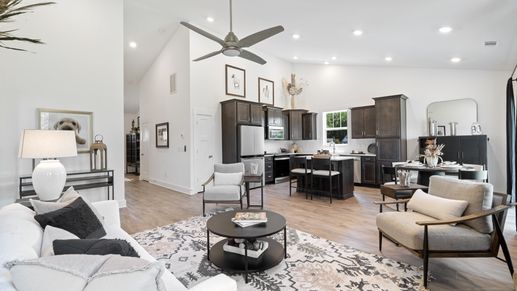 Family room at Magnolia Park in Woodruff, SC with hardwood flooring, stone fireplace, and two story ceilings by DRB Homes