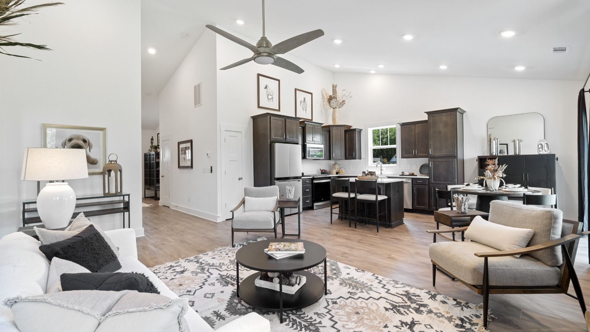 Family room at Magnolia Park in Woodruff, SC with hardwood flooring, stone fireplace, and two story ceilings by DRB Homes