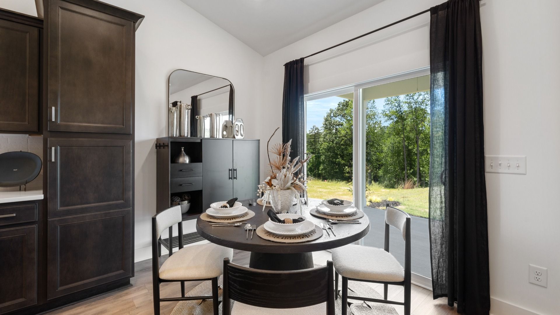 Modern breakfast room with sliding door to back porch adjacent from kitchen at Magnolia Park by DRB Homes in Woodruff, SC