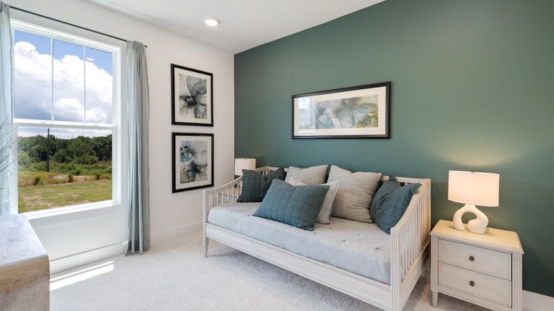Secondary bedroom at Magnolia Park with green accent wall and plush carpet in Woodruff, SC by DRB Homes