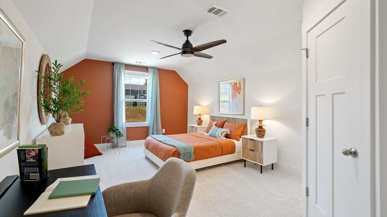 Elevated ceiling bonus room with plush carpet, ceiling fan, and large window at Magnolia Park by DRB Homes in Woodruff, SC