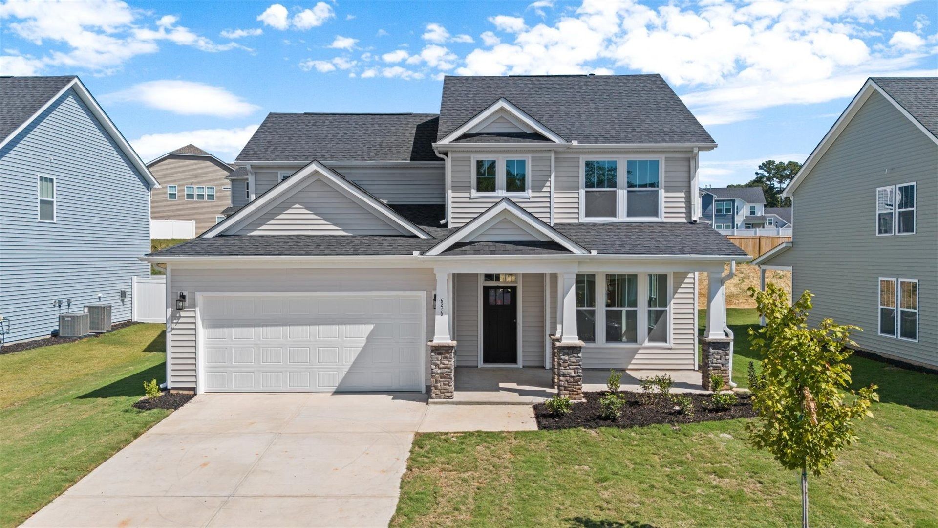 DRB Homes' Magnolia Park Middleton floorplan two story home with cream exterior with stone columns in Woodruff, SC
