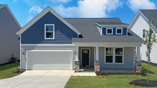 New blue and gray exterior Parker by DRB Homes with stone columns and two car garage at Walnut Ridge in Inman, SC