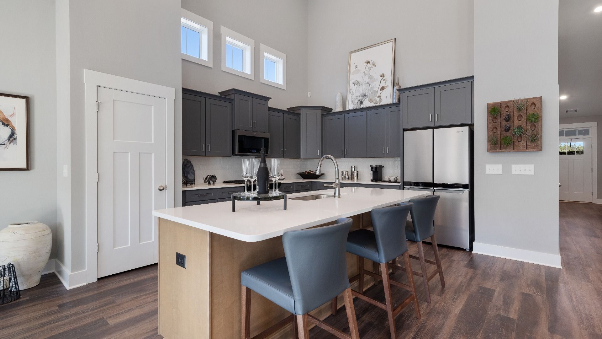 Gray cabinetry kitchen with outlook windows, wooden island with counterstools, and modern appliances in Inman, SC