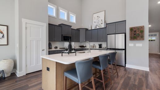 Gray cabinetry kitchen with outlook windows, wooden island with counterstools, and modern appliances in Inman, SC
