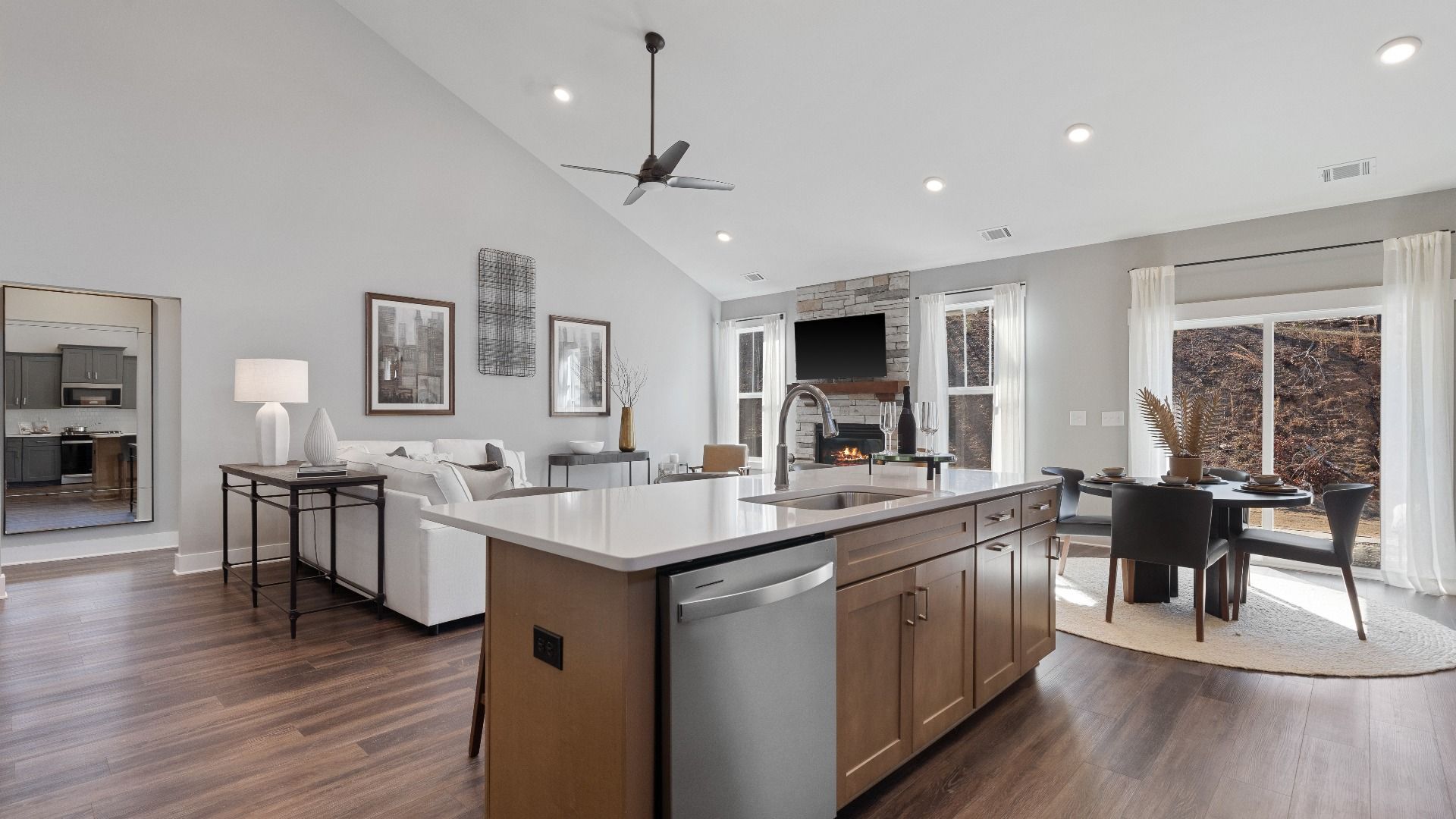 Open concept kitchen, wooden island with counterstools, modern appliances & hardwood flooring at Walnut Ridge by DRB Homes