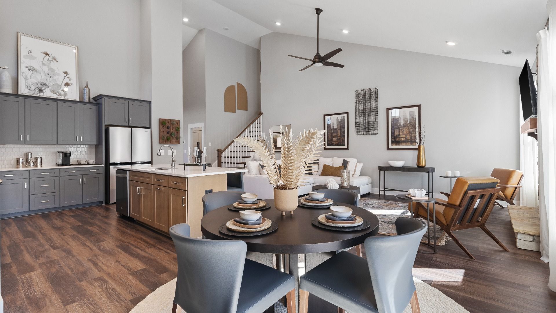 Elevated two-story ceiling open concept living spaces with hardwood flooring and large windows at Walnut Ridge by DRB Homes