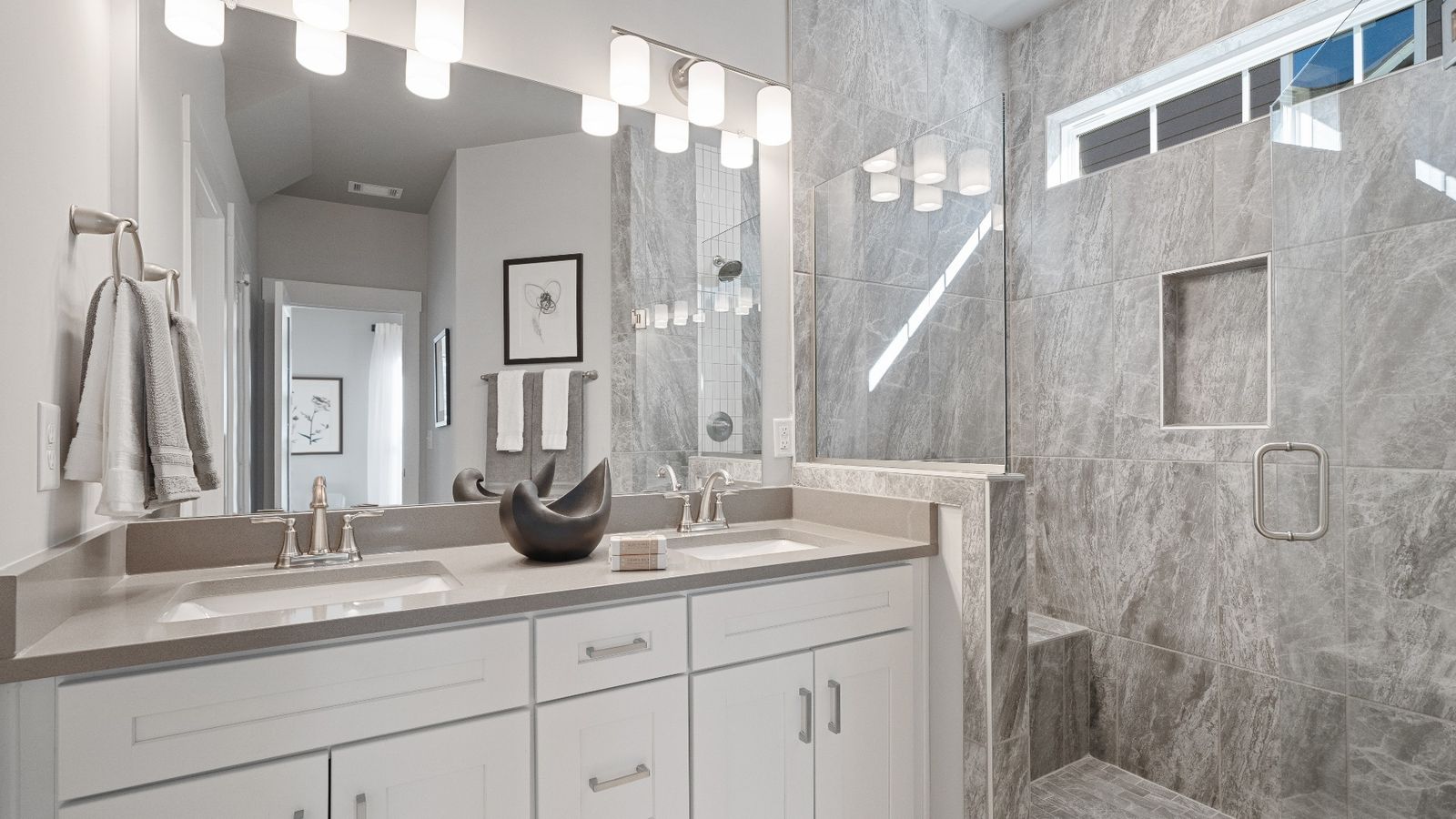 Stunning primary bathroom with tiled walk-in frameless shower with double sink vanity at Walnut Ridge by DRB Homes
