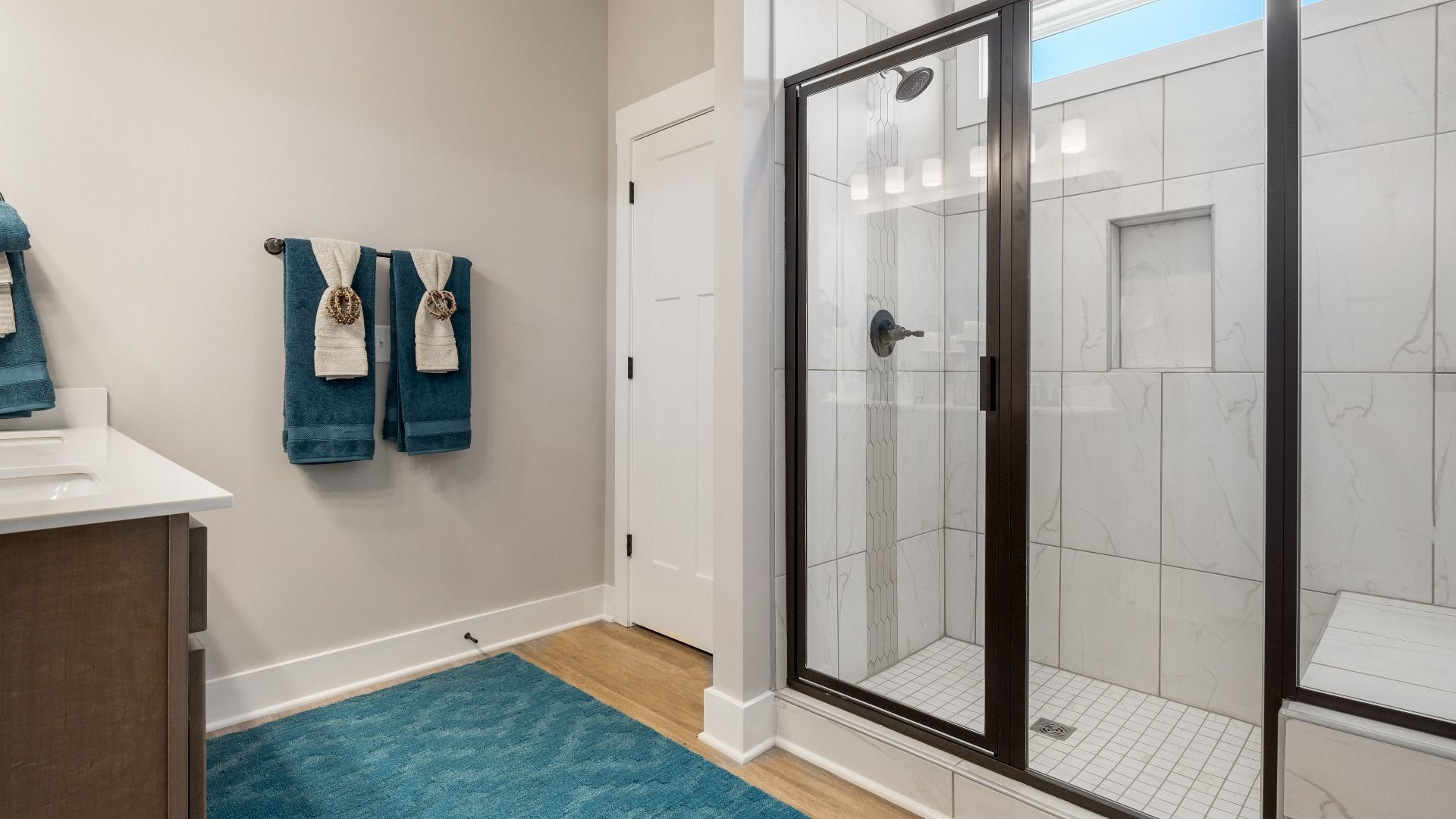 New, modern primary bathroom with black accents and blue decor at Wells Crossing by DRB Homes in Seneca, SC